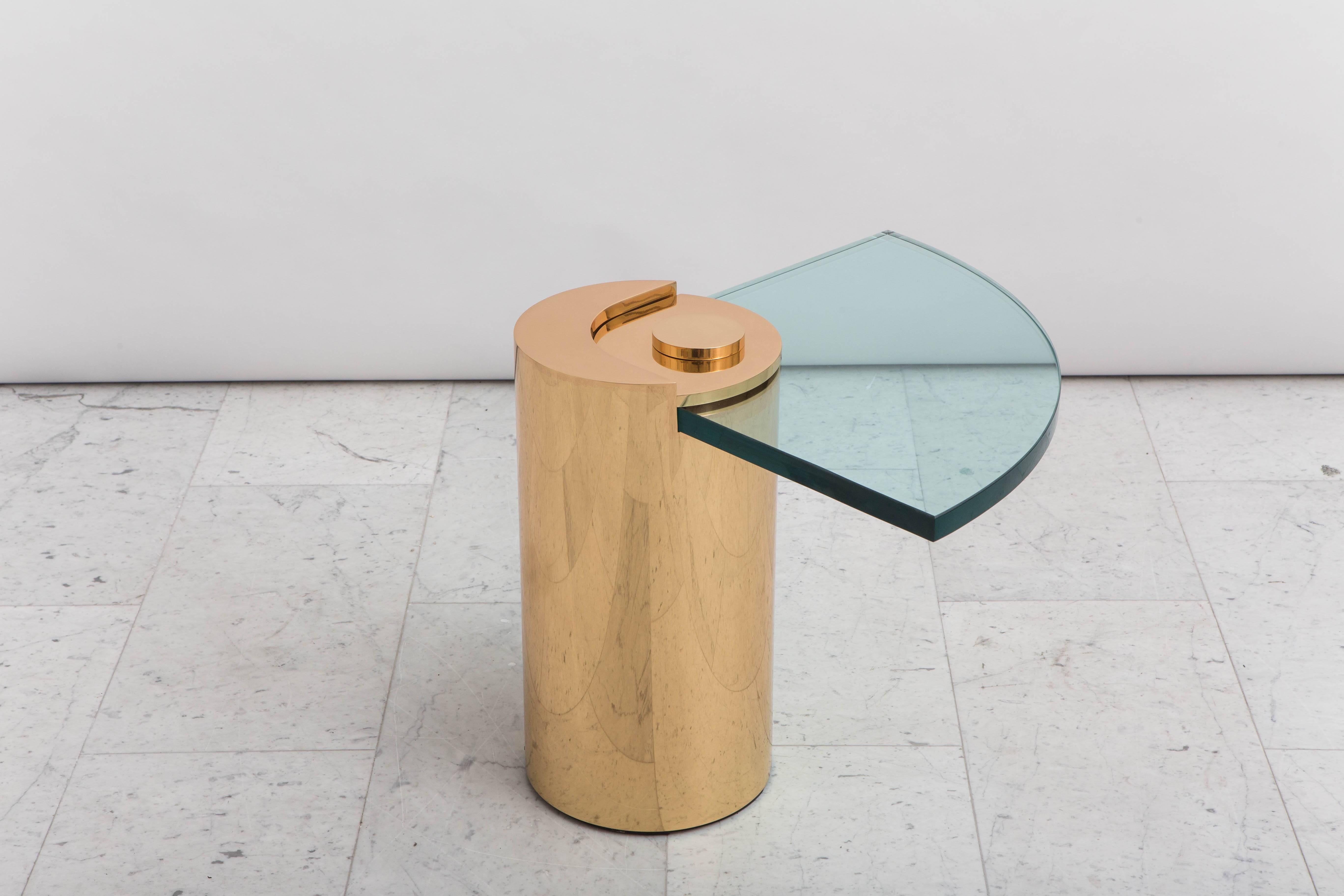 Une conception iconique de Karl Springer, la table à pieds sculptés unique a été lancée en 1971 et est rééditée aujourd'hui en exclusivité avec Todd Merrill Studio. La base métallique cylindrique en bronze poli est surmontée d'un élégant plateau en