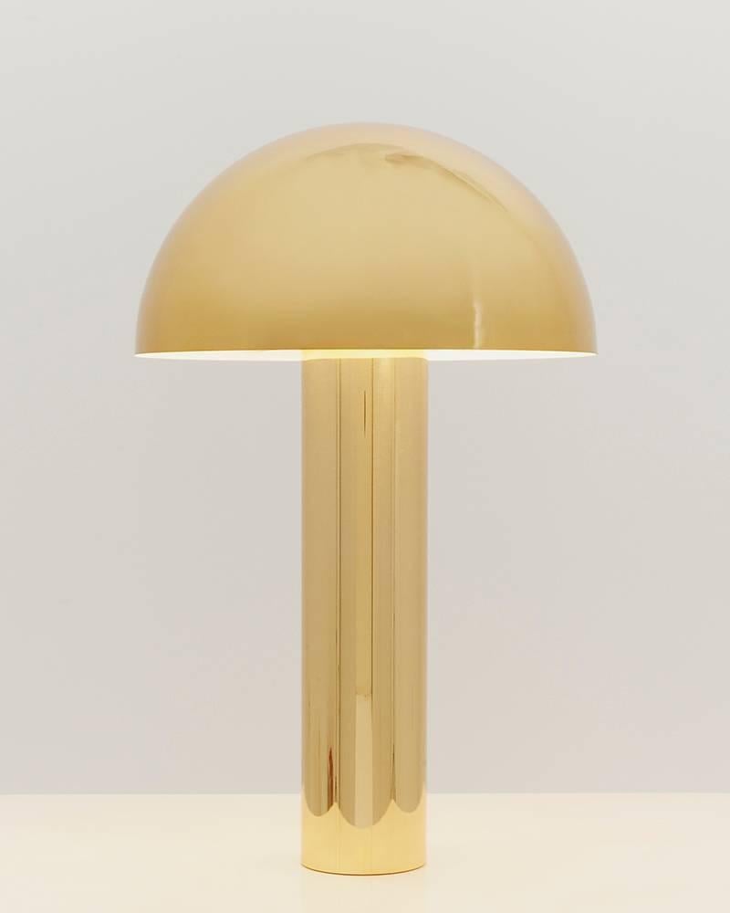 Designed by Karl Springer in the 1980s, the unique table lamp is offered today in an exclusive reissue by Karl Springer Studio for Todd Merrill Studio. The high polished lamp features a brass cylindric base and rounded shade. A small dimming knob at