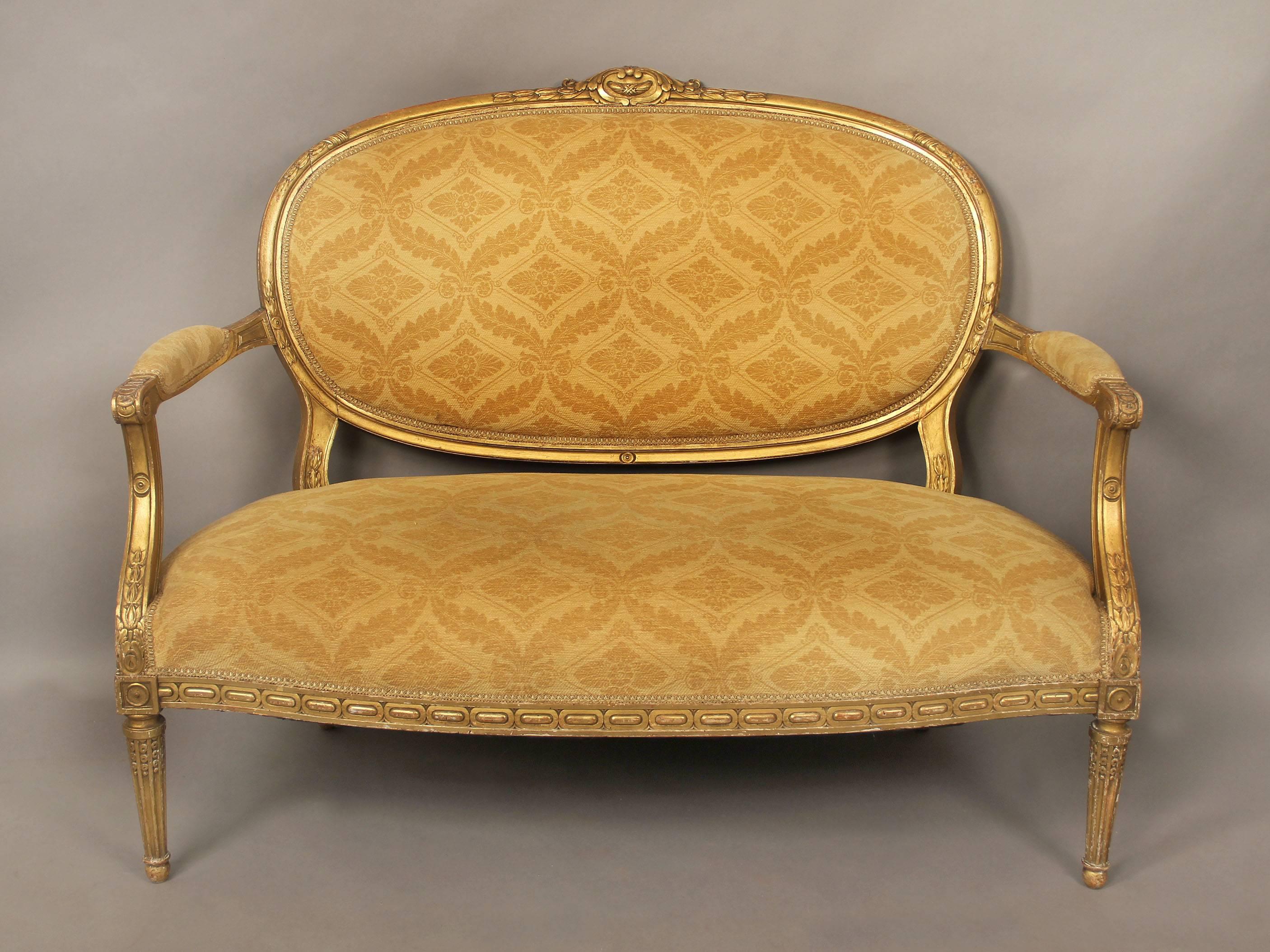 A very nice late 19th century three-piece Louis XVI style giltwood parlor set.

Consisting of a settee and a pair of arm chairs, beautiful carved designs on the arms and legs, the settee with an oval back.

 Settee:
Height 39 inches /