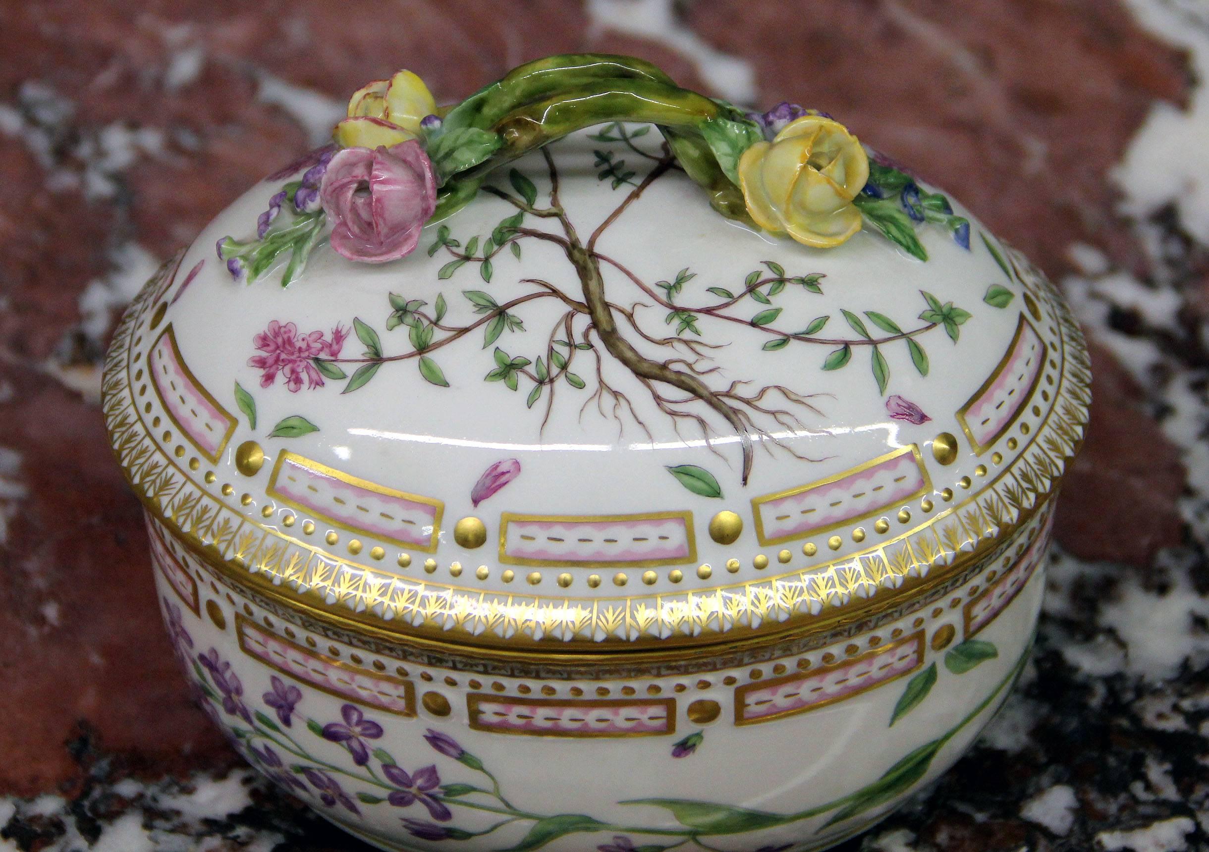 A 20th century Flora Danica large sugar bowl with cover.

Finely decorated with gold accent designs, raised porcelain flowers and handle, and 