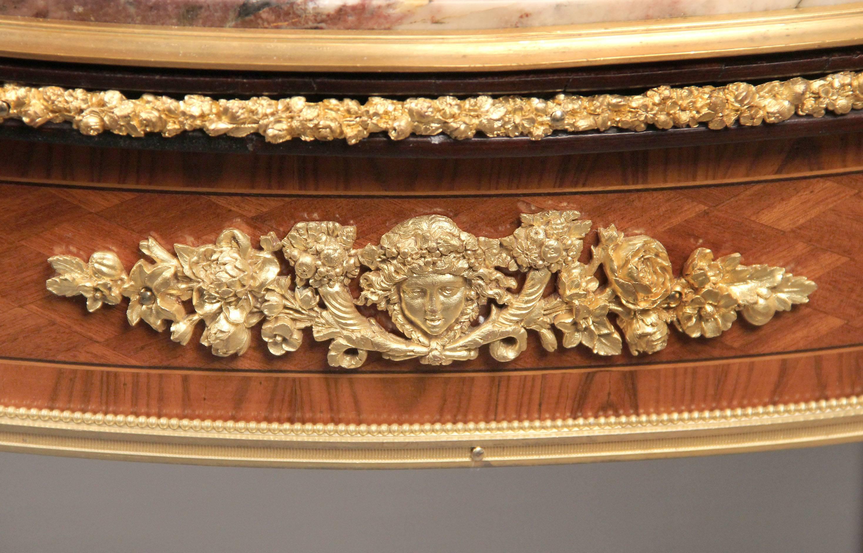 A fantastic quality late 19th century Louis XV style gilt bronze-mounted lamp table

Marble-top above a frieze drawer applied with a female mask framed by cornucopia and trailing flowers, the bronze-mounted cabriole legs joined by a bronze mounted