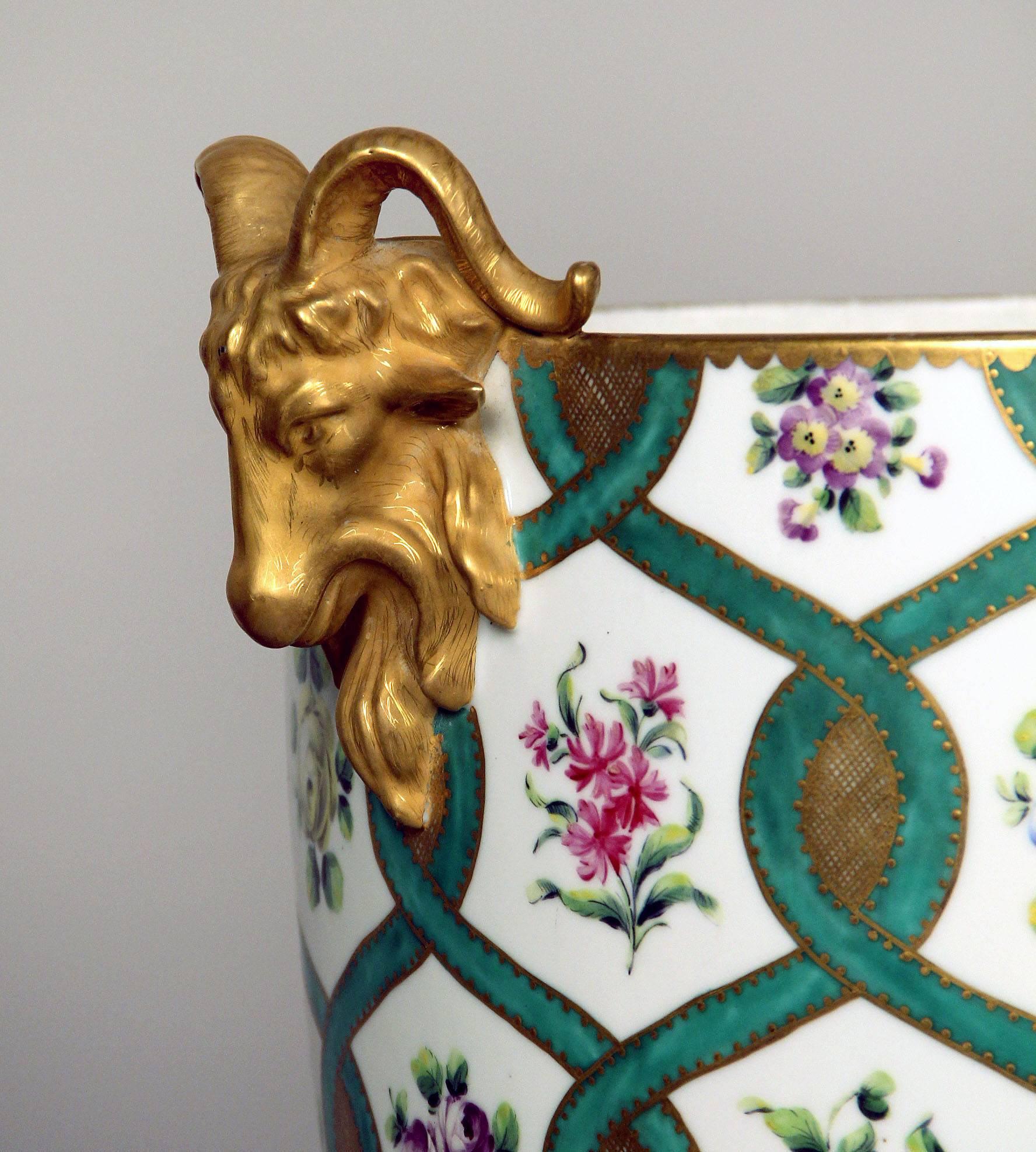 Jardinière en porcelaine de la fin du XIXe siècle, de style Sèvres, à parquets dorés

Finement peint de nombreuses fleurs colorées avec des garnitures vertes et dorées, des têtes de bélier dorées de chaque côté.

Fin 1739-début 1740, la