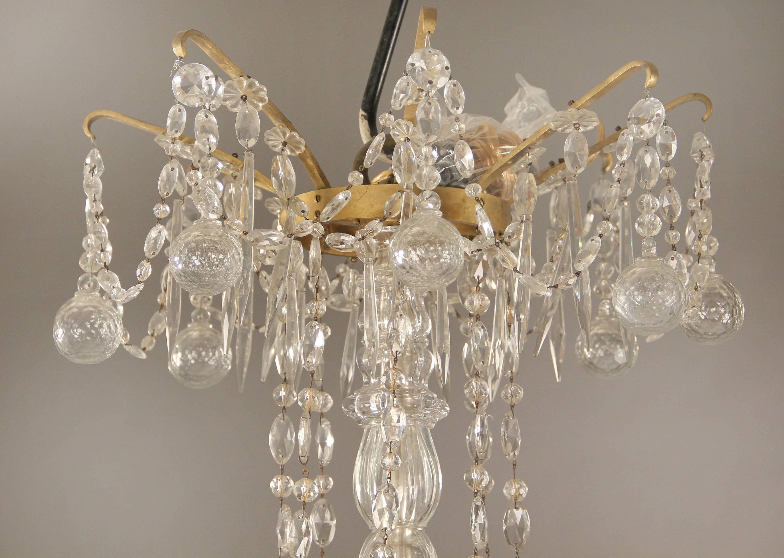 A very fine and palatial pair of late 19th century gilt bronze and crystal twenty-four-light chandeliers

Multifaceted and shaped crystal, cut crystal central column beaded swags from arm to arm. 16-tiered perimeter and eight interior lights,