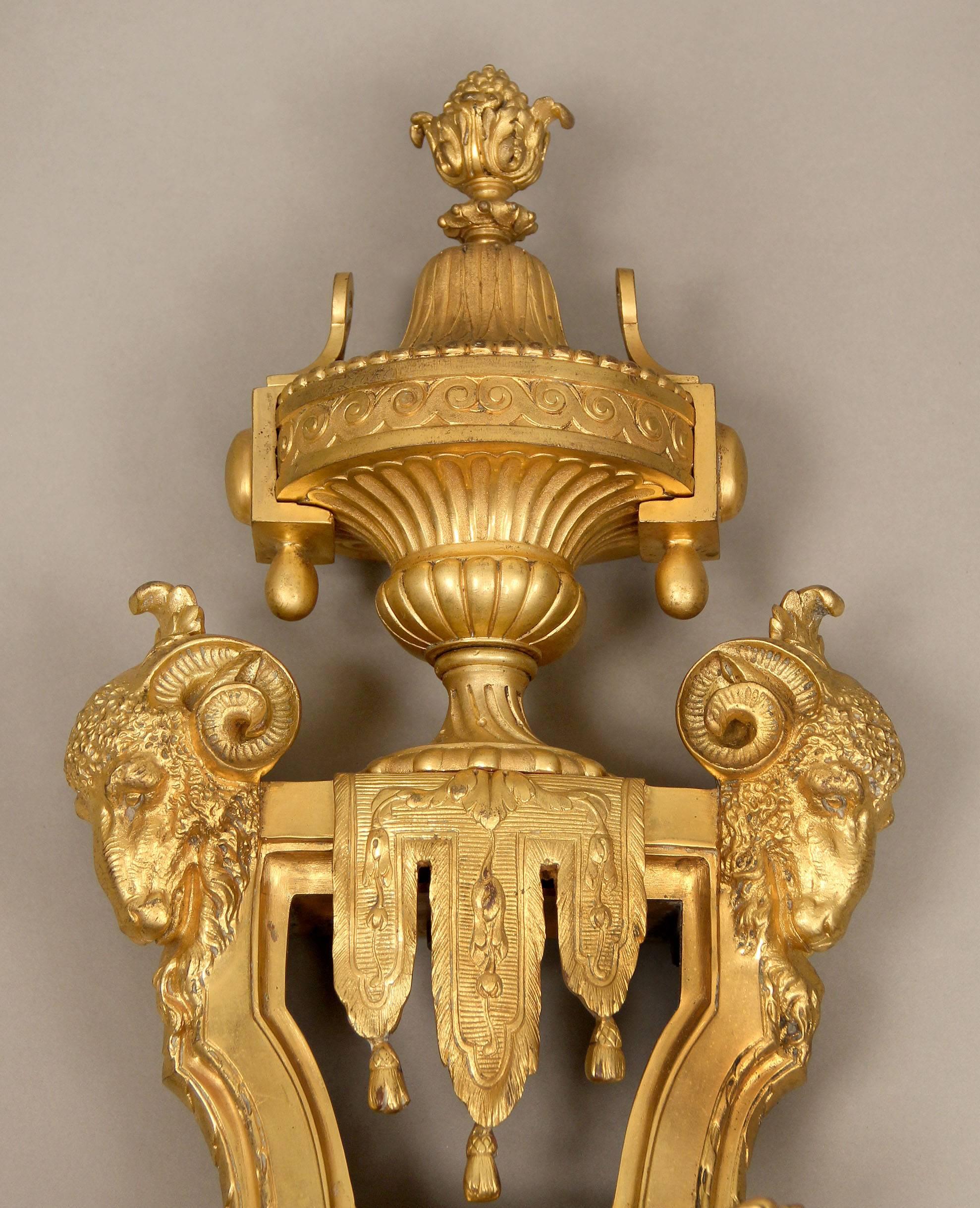 A palatial and unique late 19th-early 20th century gilt bronze Cartel clock

By François Linke

The heavy and great quality bronze clock is topped by an urn with rams heads and curtains, centered with three large cherubs floating in clouds,