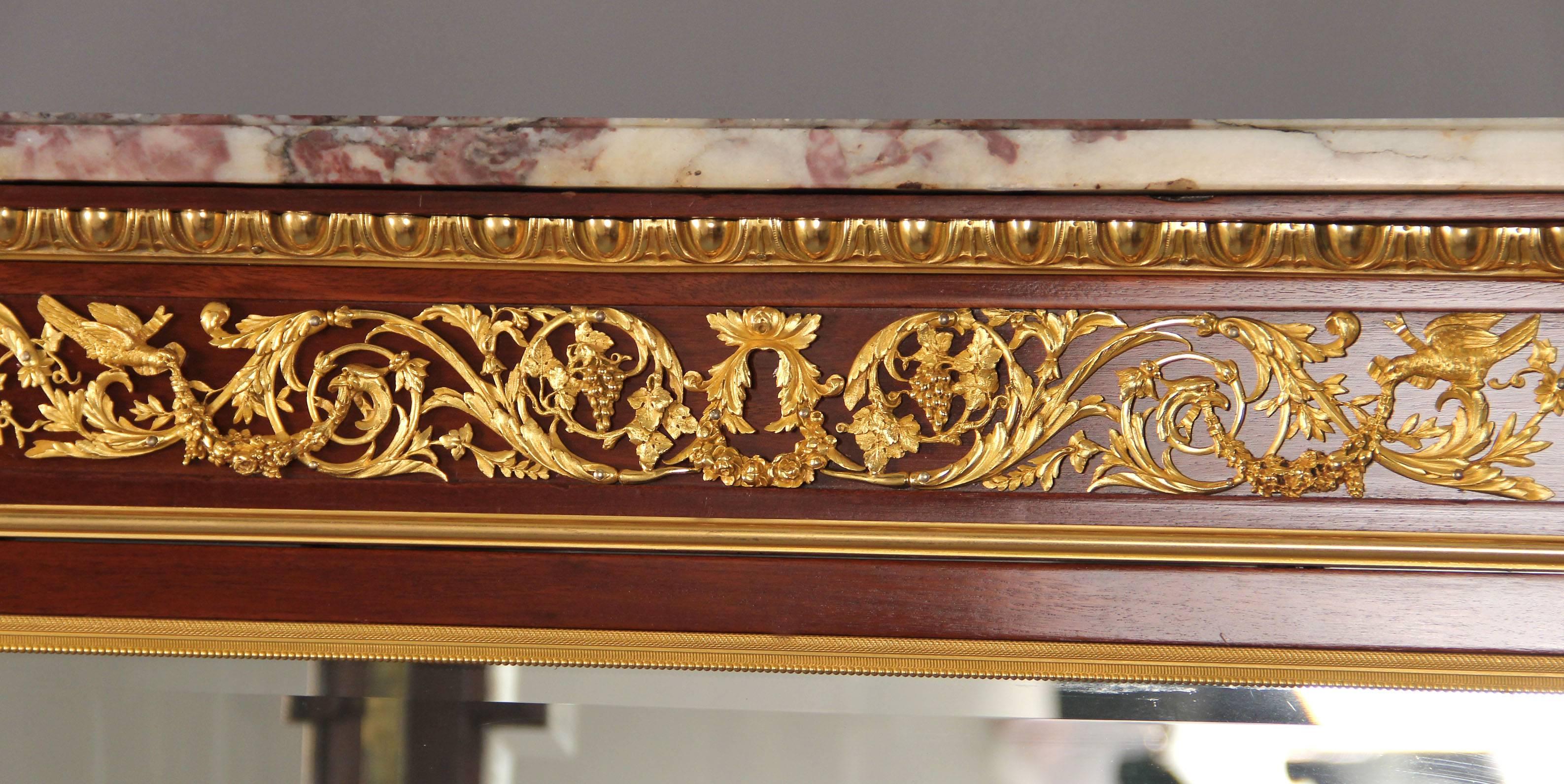 Early 20th century Louis XVI style gilt bronze-mounted parquetry vitrine

by François Linke.

Index number 458.

The fleur de pêcher marble-top above a scrolling acanthus and floral-festooned frieze, over a bevelled glazed door with parquetry