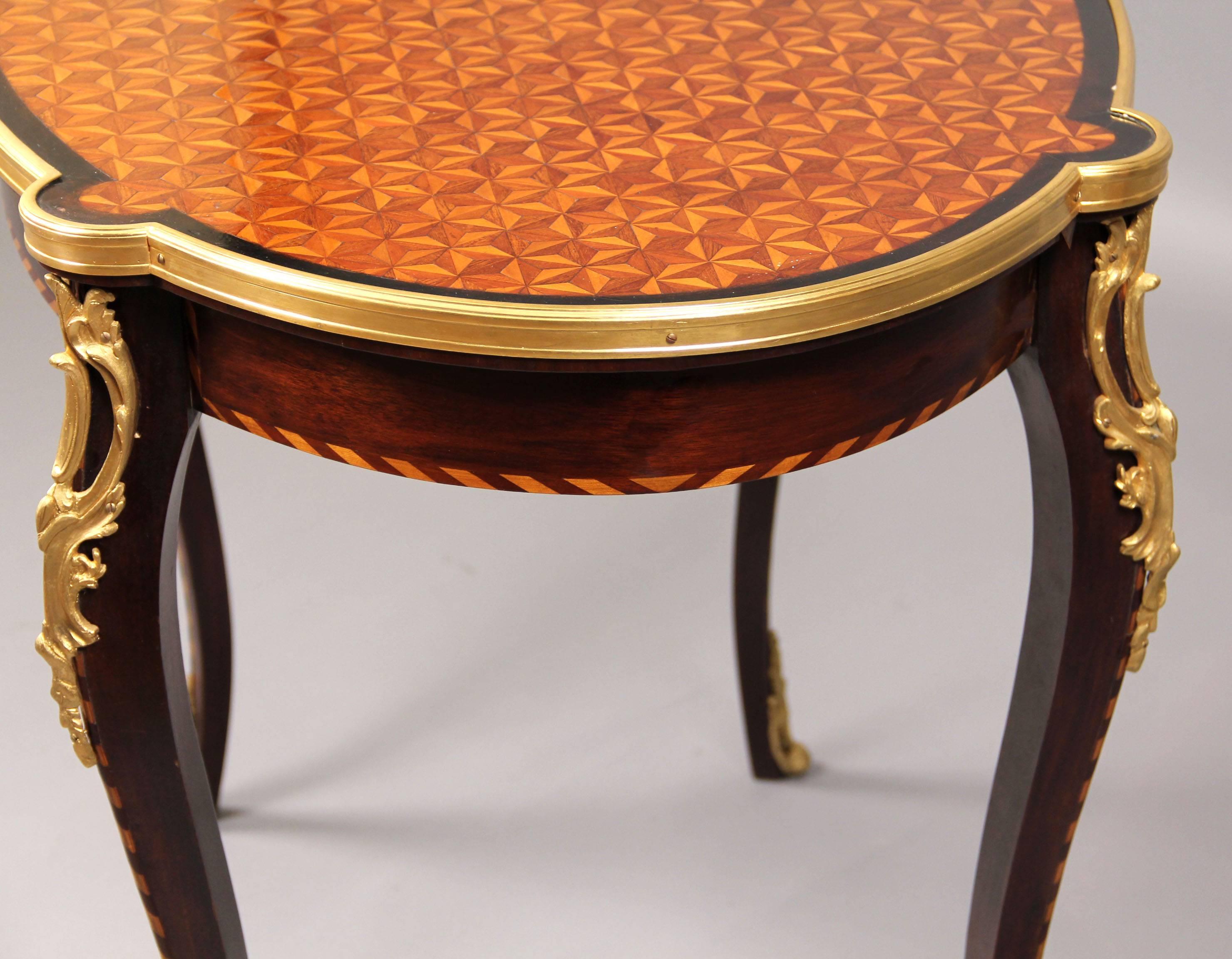 Late 19th century Louis XV style gilt bronze mounted parquetry-top center table.

Oval parquetry-top raised by bronze mounted cabriole legs.