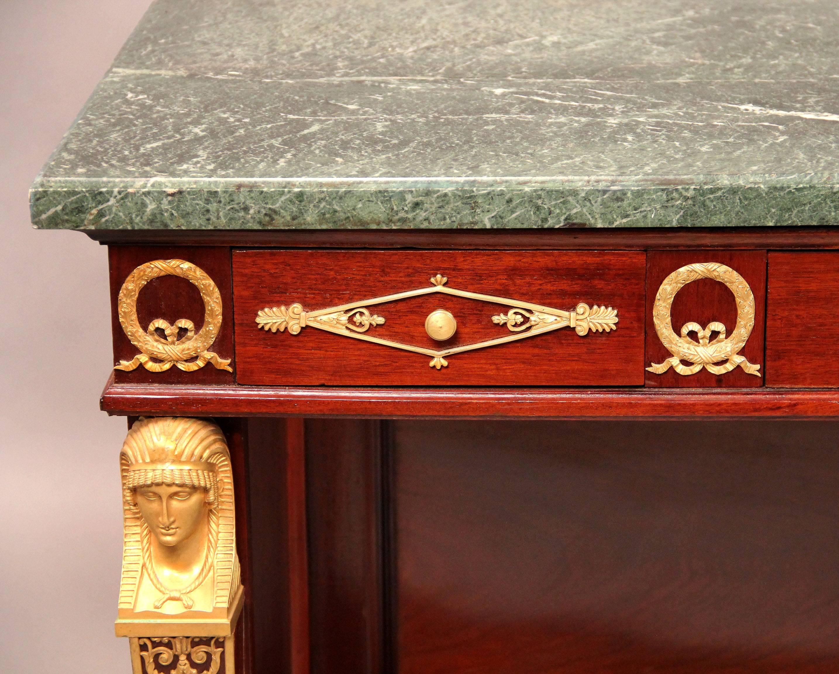 An exceptionally fine late 19th century gilt bronze-mounted Empire style marble top console.

Verde antico marble top, above three bronze-mounted drawers, front legs bronze mounted, all raised on bun feet.