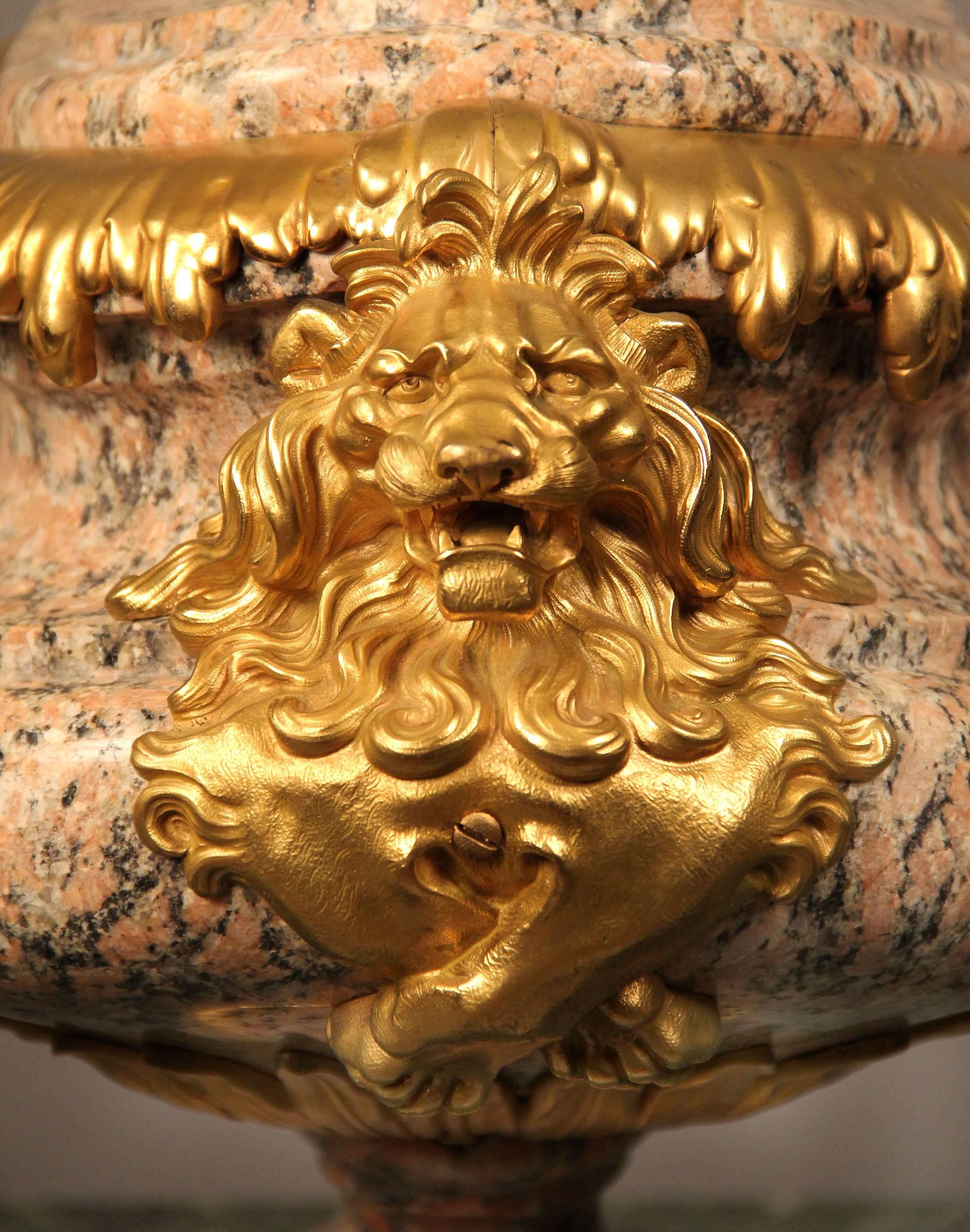 A very fine French late 19th century rose granite and gilt bronze-mounted centerpiece,

of oval form, the sides with lion masks and the incurved top surmounted by a berry and acanthus.