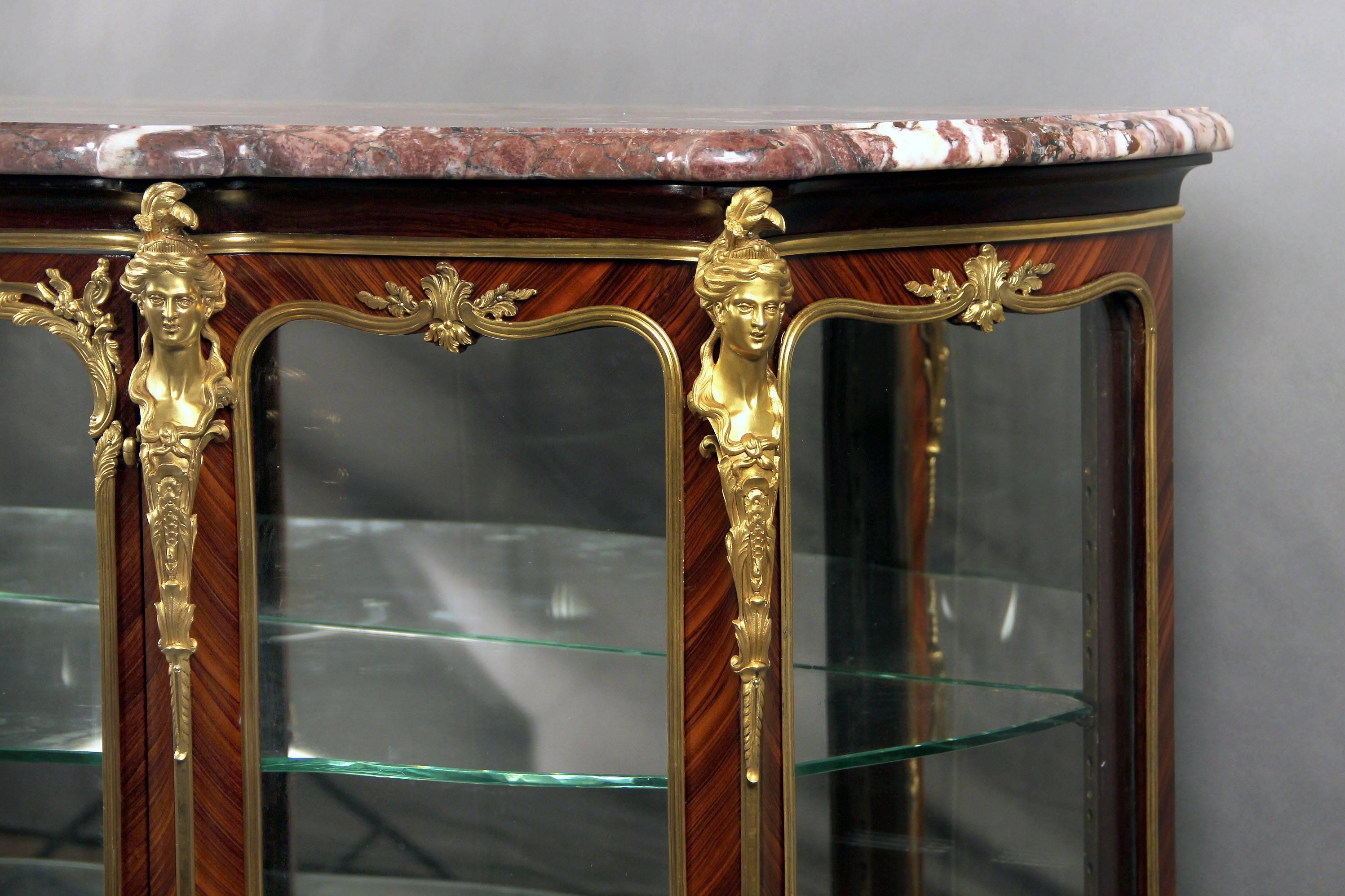 A fantastic late 19th century Louis XV style gilt bronze-mounted kingwood vitrine.

By François Linke.

The fleur de pêcher marble top above a central glazed door, the corners of the front with beautiful female bronze bust. Typical Linke