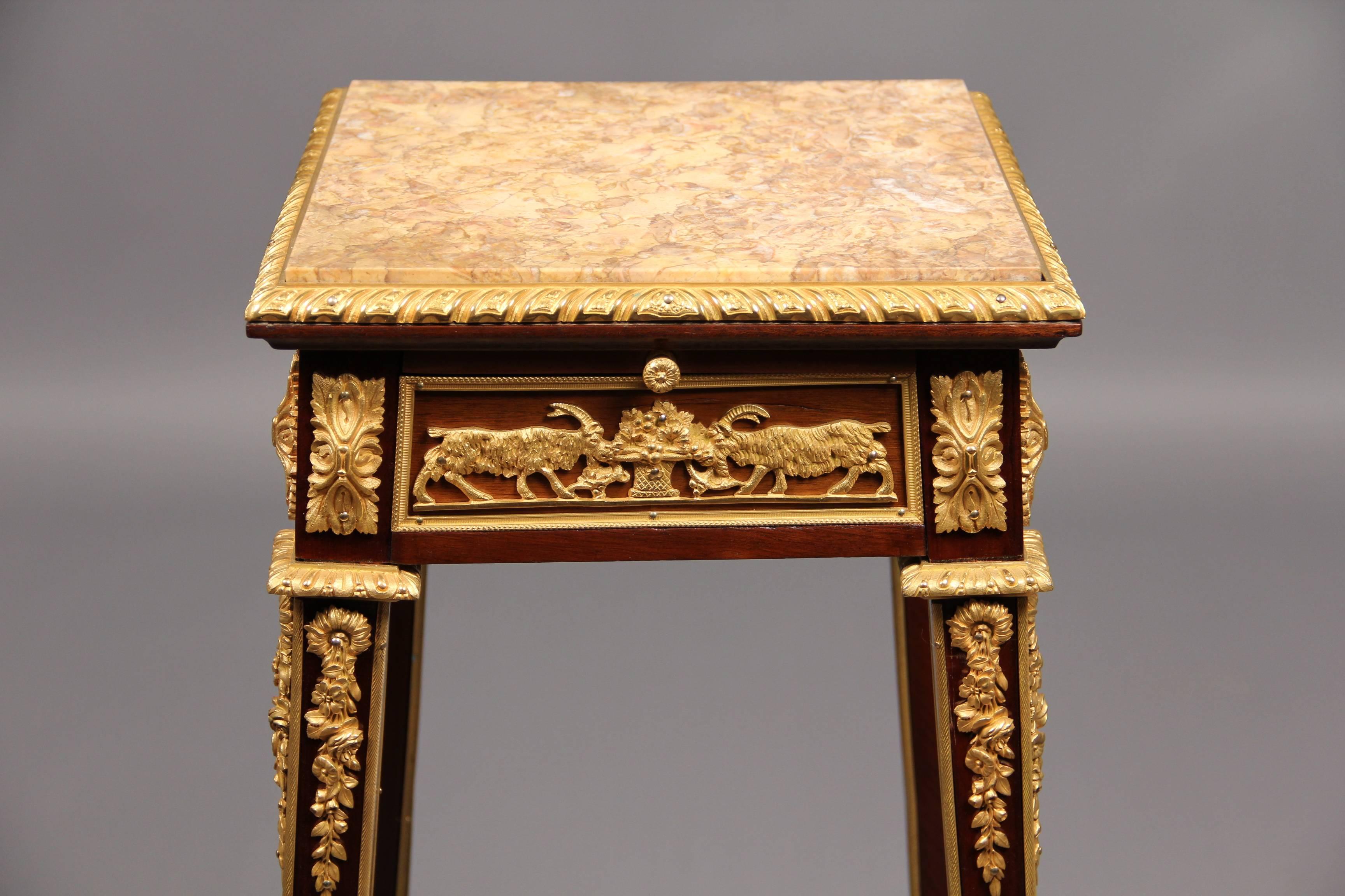 Late 19th century gilt bronze-mounted marble-top pedestal.

Fitted with a pullout writing surface and a frieze drawer, the bronze-mounted tapered legs joined by a bronze-mounted stretcher centred by a bronze urn.