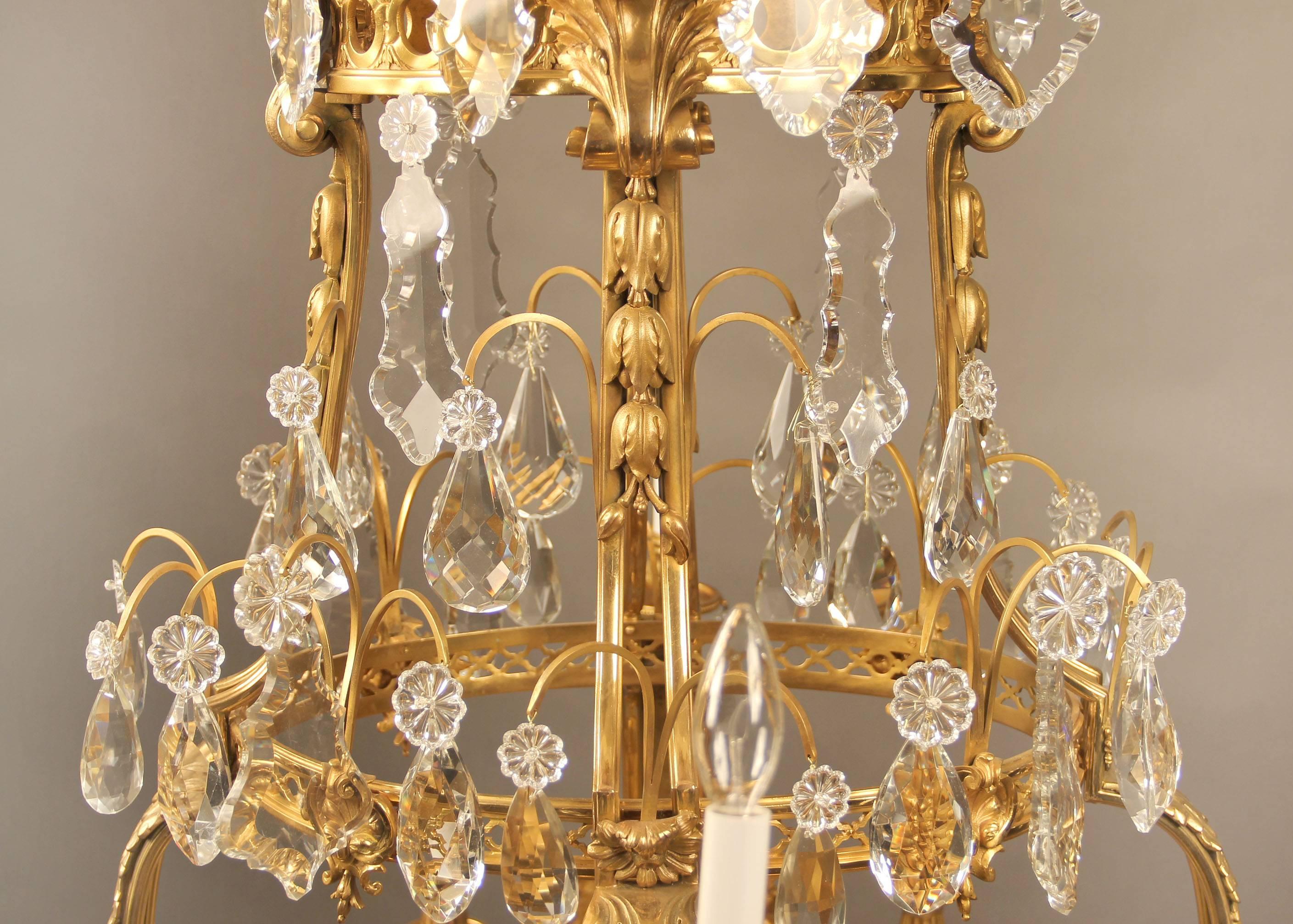 A unique late 19th century gilt bronze and cut crystal Regence style seventeen-light chandelier.

Heavy bronze casted cage in oval form, multifaceted and shaped crystal, lower ring applied with masks and oak leaves, twelve perimeter and five tiered