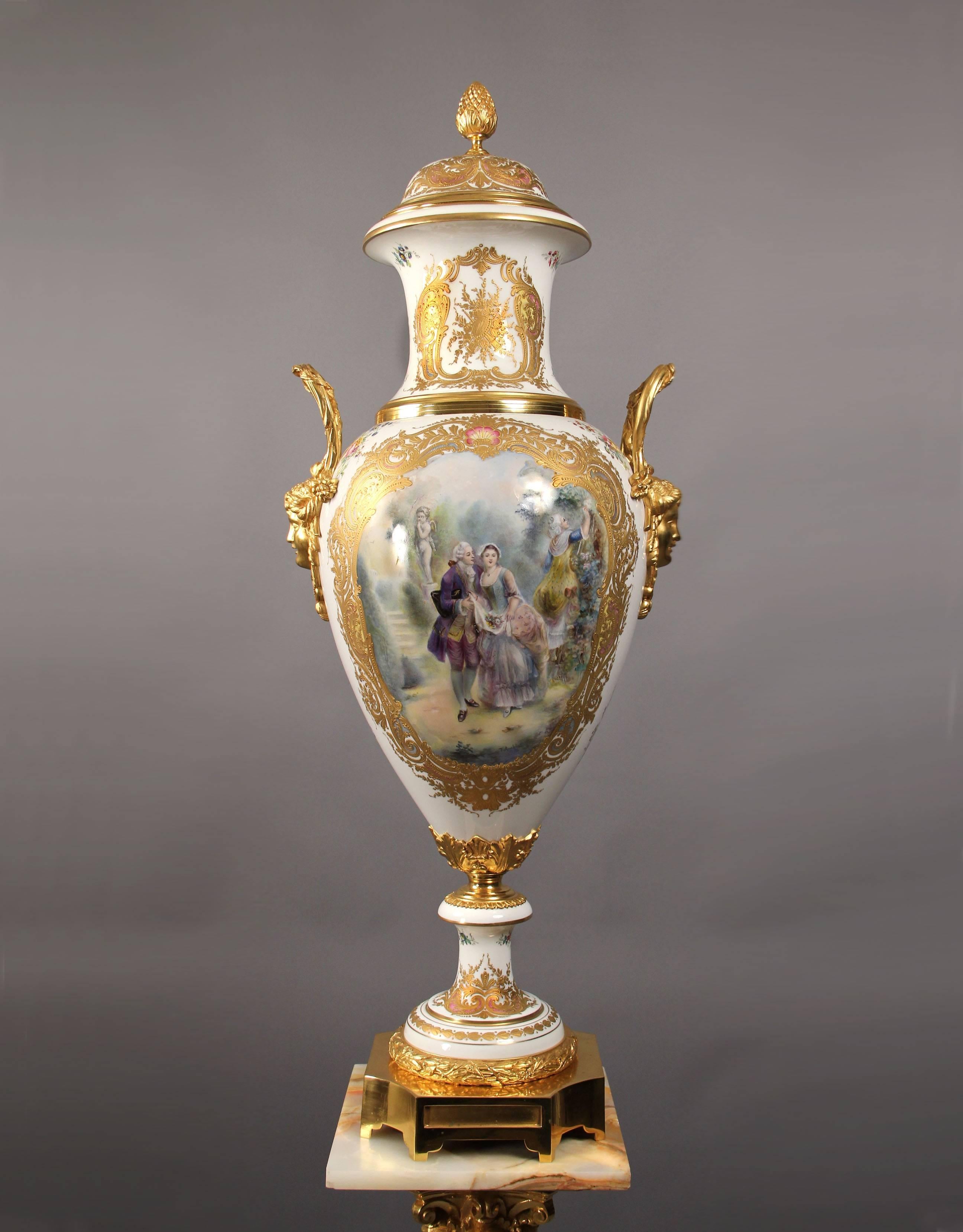 A fantastic late 19th century gilt bronze-mounted onyx and white Sèvres style pedestal with matched vase.

The vase of baluster form, the domed cover surmounted by a pinecone finial, painted with an amorous 18th century couple in a garden setting