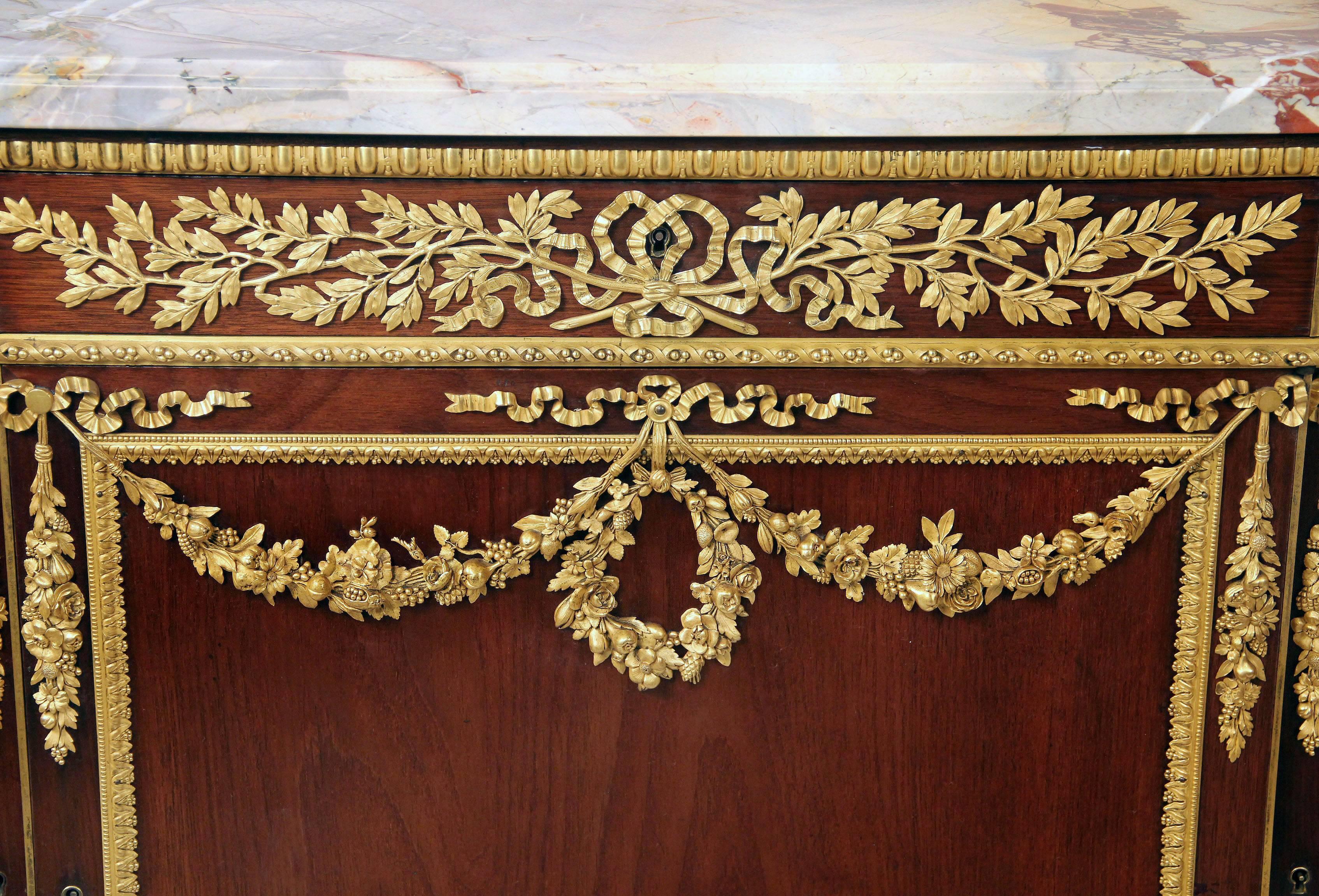 Exceptionnelle commode de style Louis XVI de la fin du XIXe siècle, montée en bronze doré.

Par Henry Dasson

Un plateau en marbre surmontant une frise de trois tiroirs à décor de lauriers percés, surmontant trois portes d'armoire en guirlande