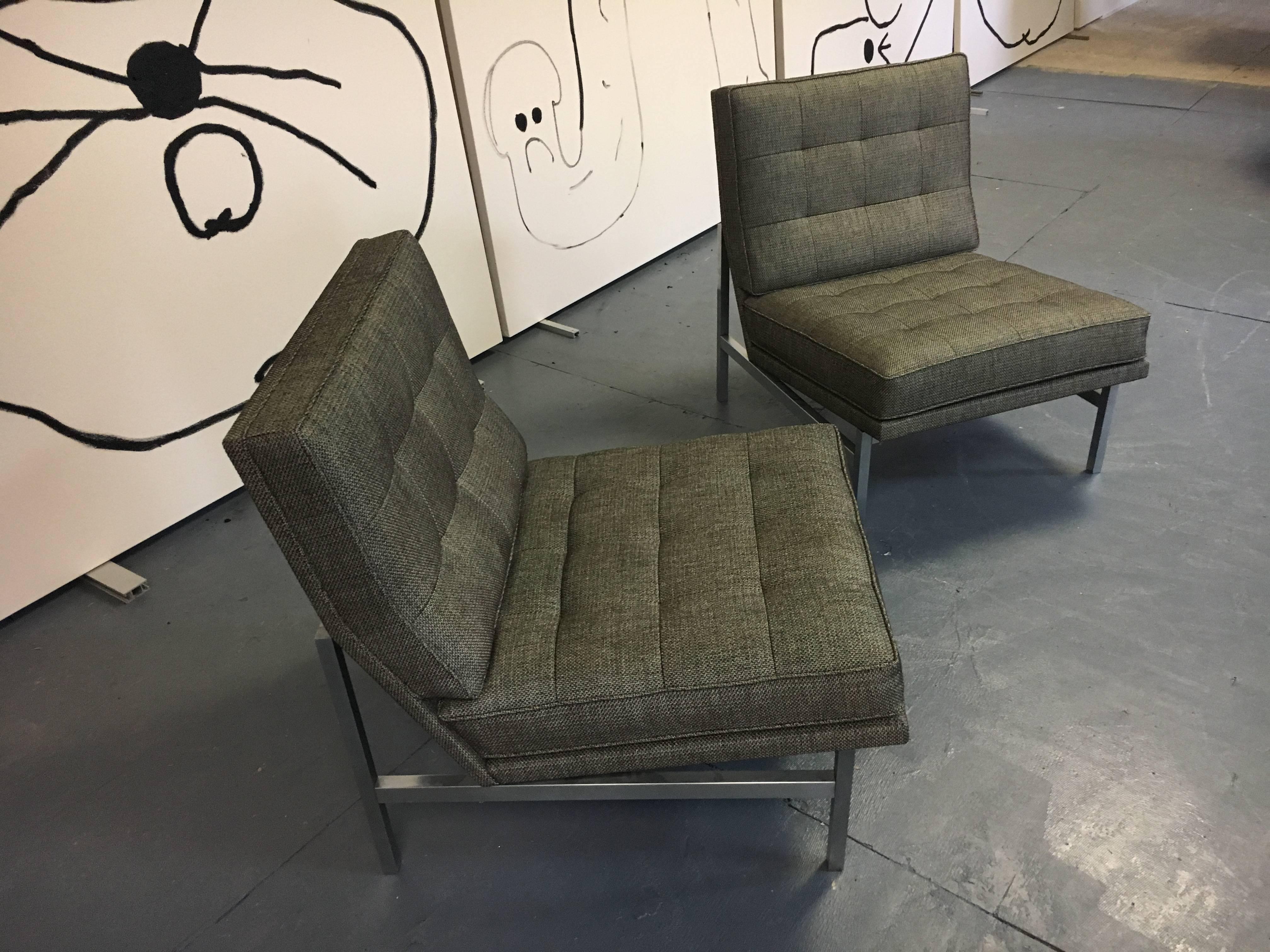 A pair of lounge chairs designed by Florence Knoll in 1958 and manufactured by Knoll. Square tubular steel base in upholstered in Knoll fabric.