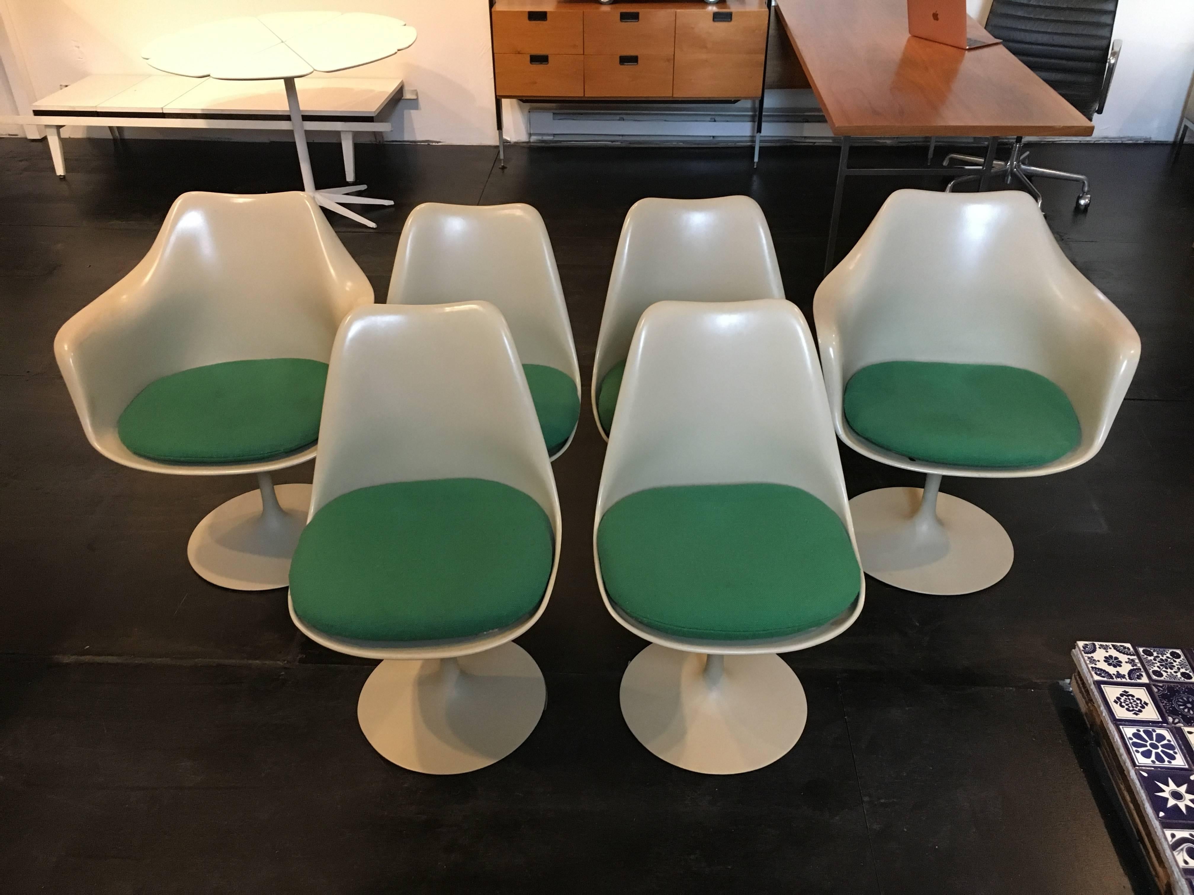 Set of six Eero Saarinen designed tulip chairs manufactured by Knoll. Set includes two armchairs and four side chairs. All chairs have swivel bases and original Knoll cushions.