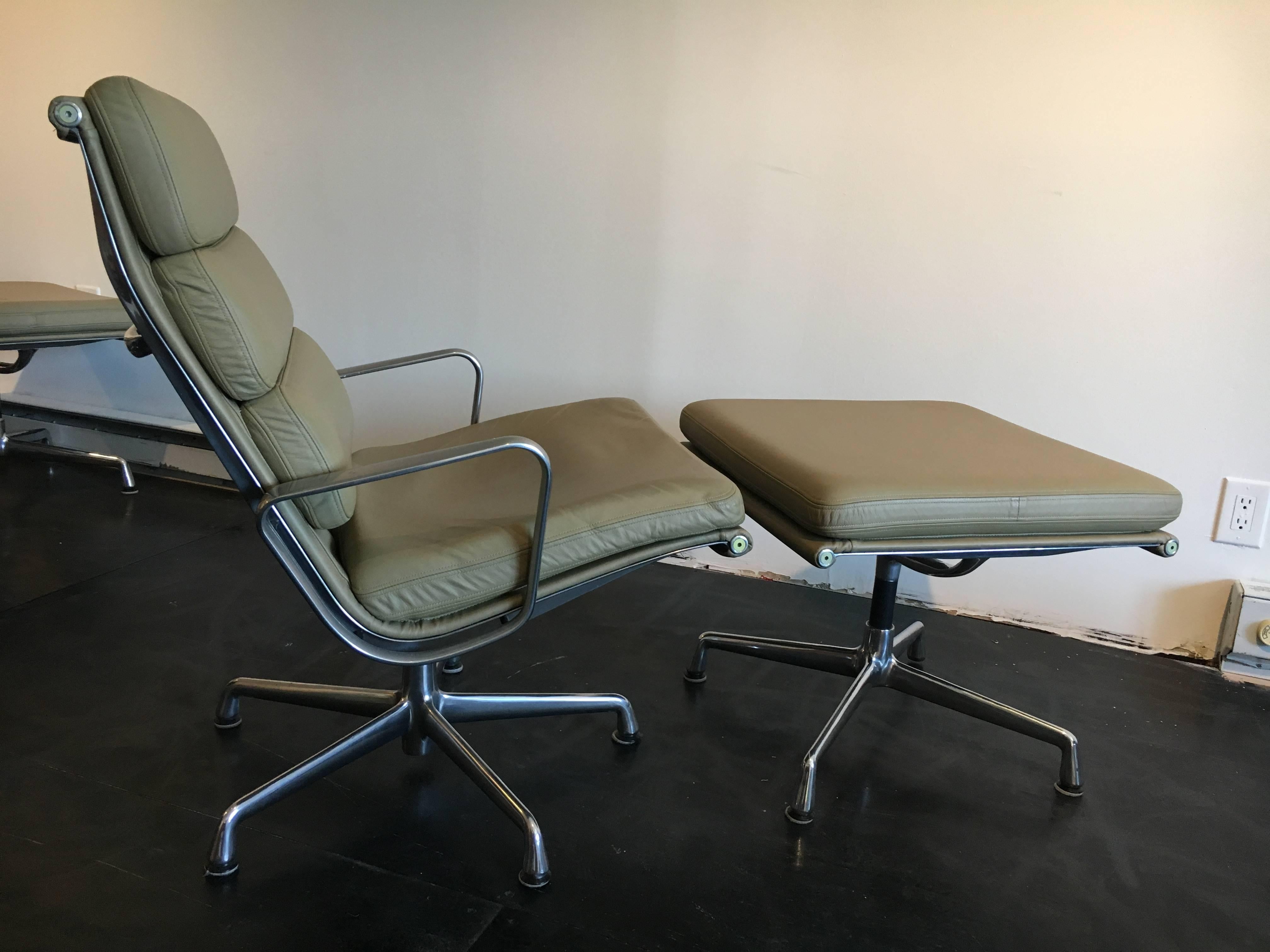 Pair of soft pad lounge chairs with ottomans, designed as part of the aluminum group by Charles & Ray Eames for Herman Miller.

Beige leather, chairs swivel.
Ottoman measurement is 21" D x 22" W x 18 " H.
  