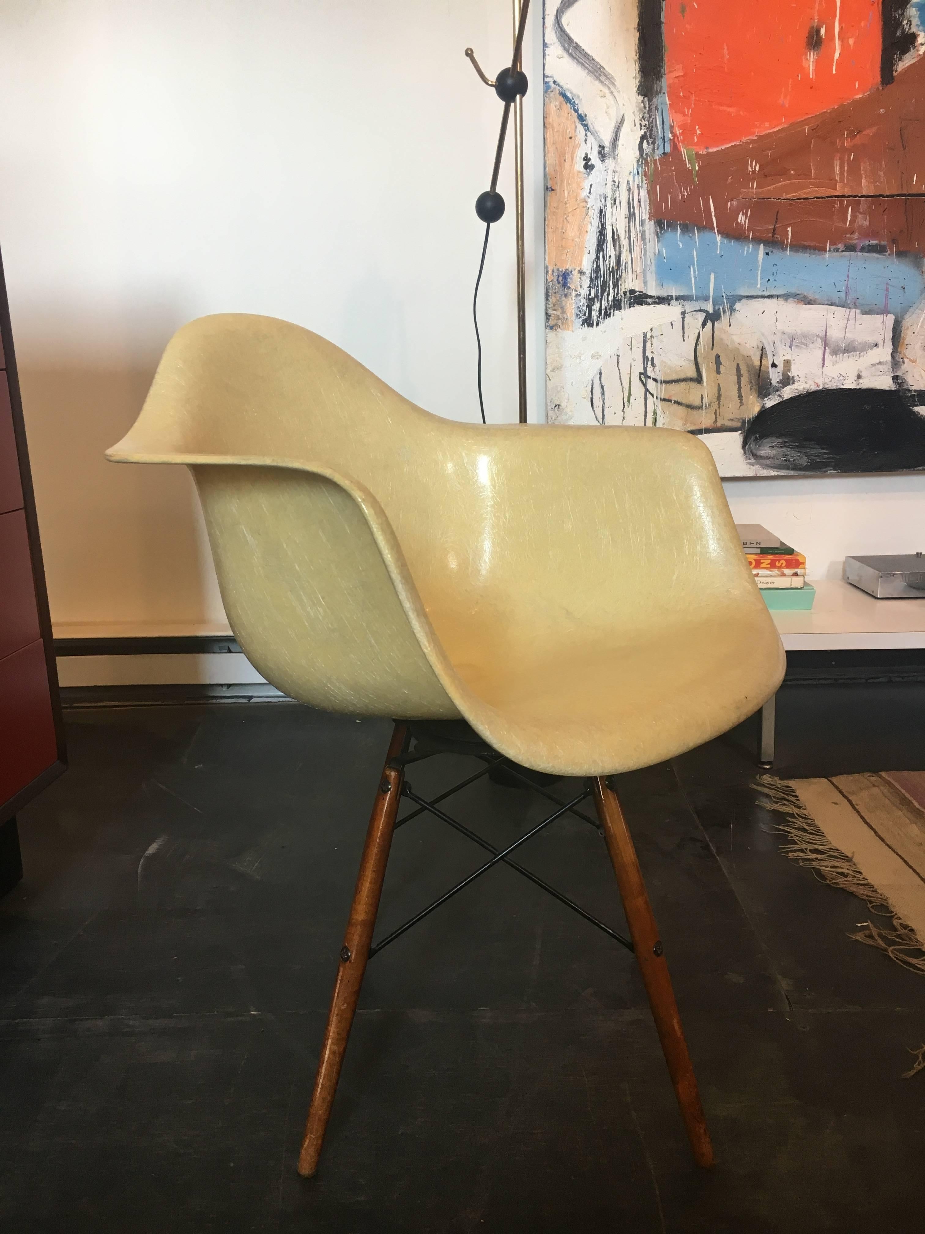 First generation 1949-1950 PAW rope swivel chair designed by Charles & Ray Eames produced by Zenith Herman Miller. Parchment color, dowel legs in birch, swivel dowel base, fiberglass shell with rope edge in parchment yellow (faded), aged in a good