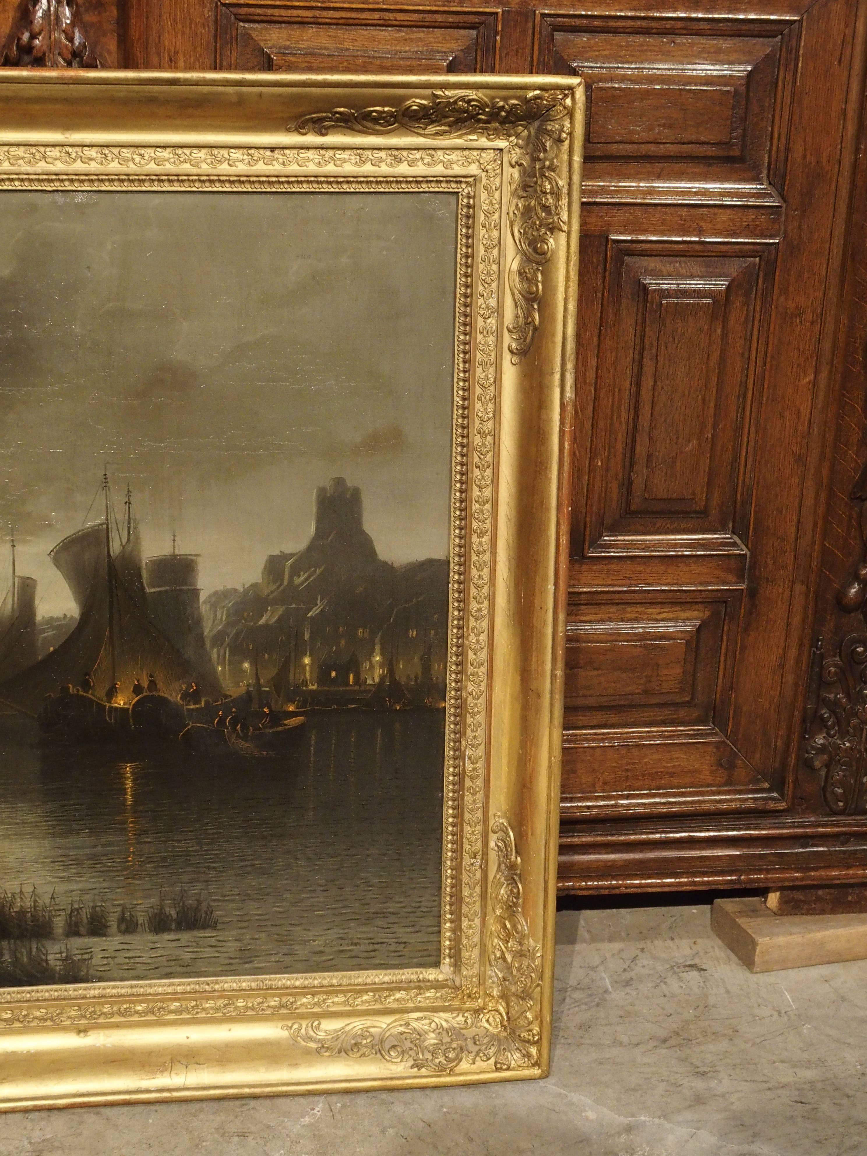 This appealing antique French Oil Painting depicts a night time harbor scene.  The moon is passing through some large dark clouds in the sky and highlighting the gently rippling waters of the wetlands and harbor. On the far right hand side, is a