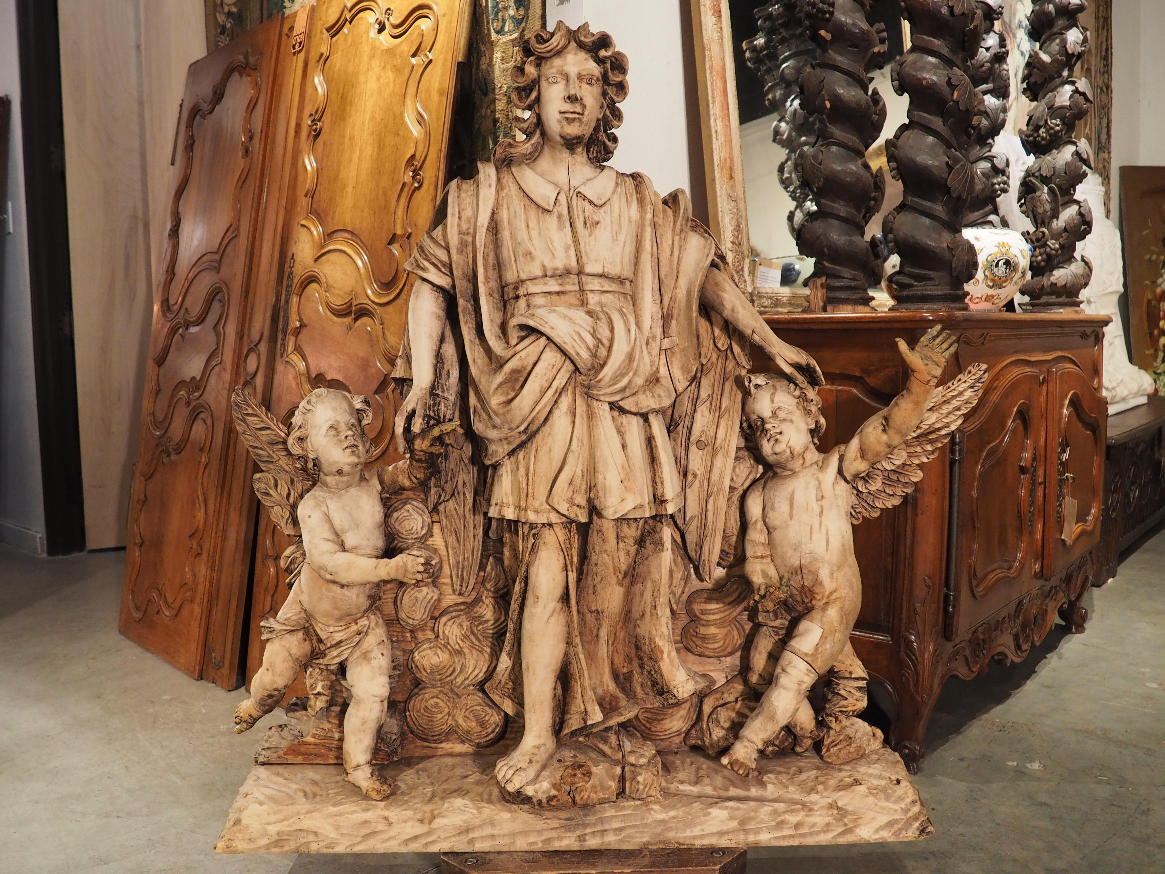 European Large 18th Century Wooden Carving of an Angel with Cherubs For Sale
