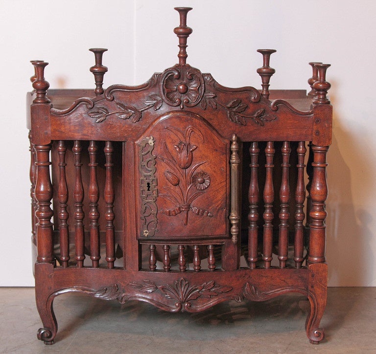 This beautifully carved French panetiere has been made from walnut wood and dates to the 1700’s. The arched top is defined by s-scrolls and characteristic turned finials.  The frieze has a central shell enclosed by two c-scrolls facing each other