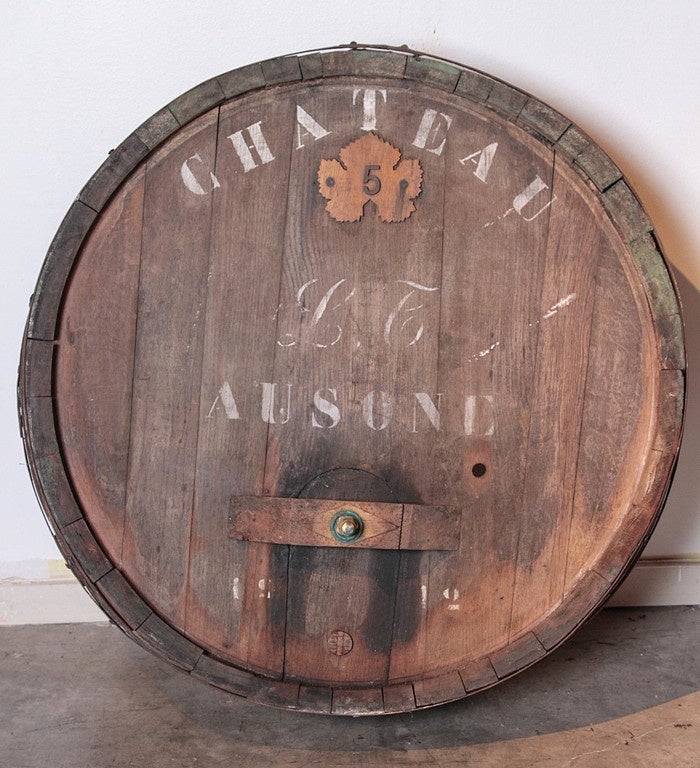 This large, painted, antique French wine barrel frontage has Chateau Ausone printed on the front, L F in script, and a number 5 on a raised carved oak leaf.  Beneath the lettering, is a 