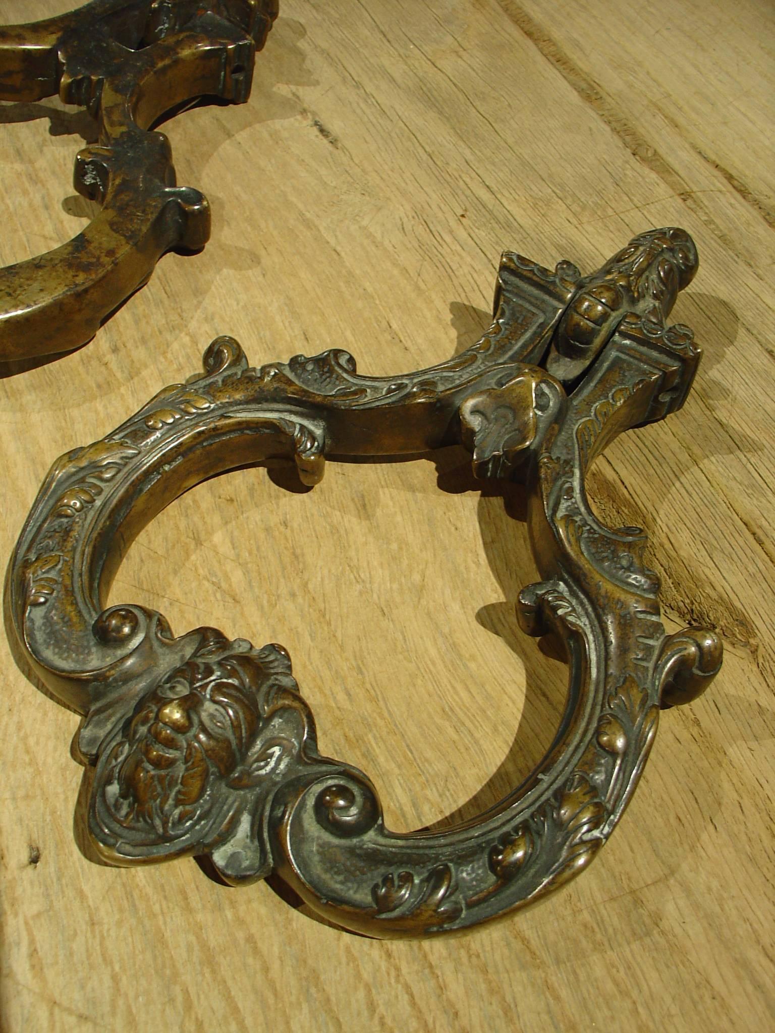 These fabulous Venetian bronze door knockers are in the form of an outline of a cartouche. They date to the late 1600’s/early 1700’s. The motifs are acanthus leaves, stylized dolphins, c-scrolls, patterned grounds, and mascarons or perhaps an image
