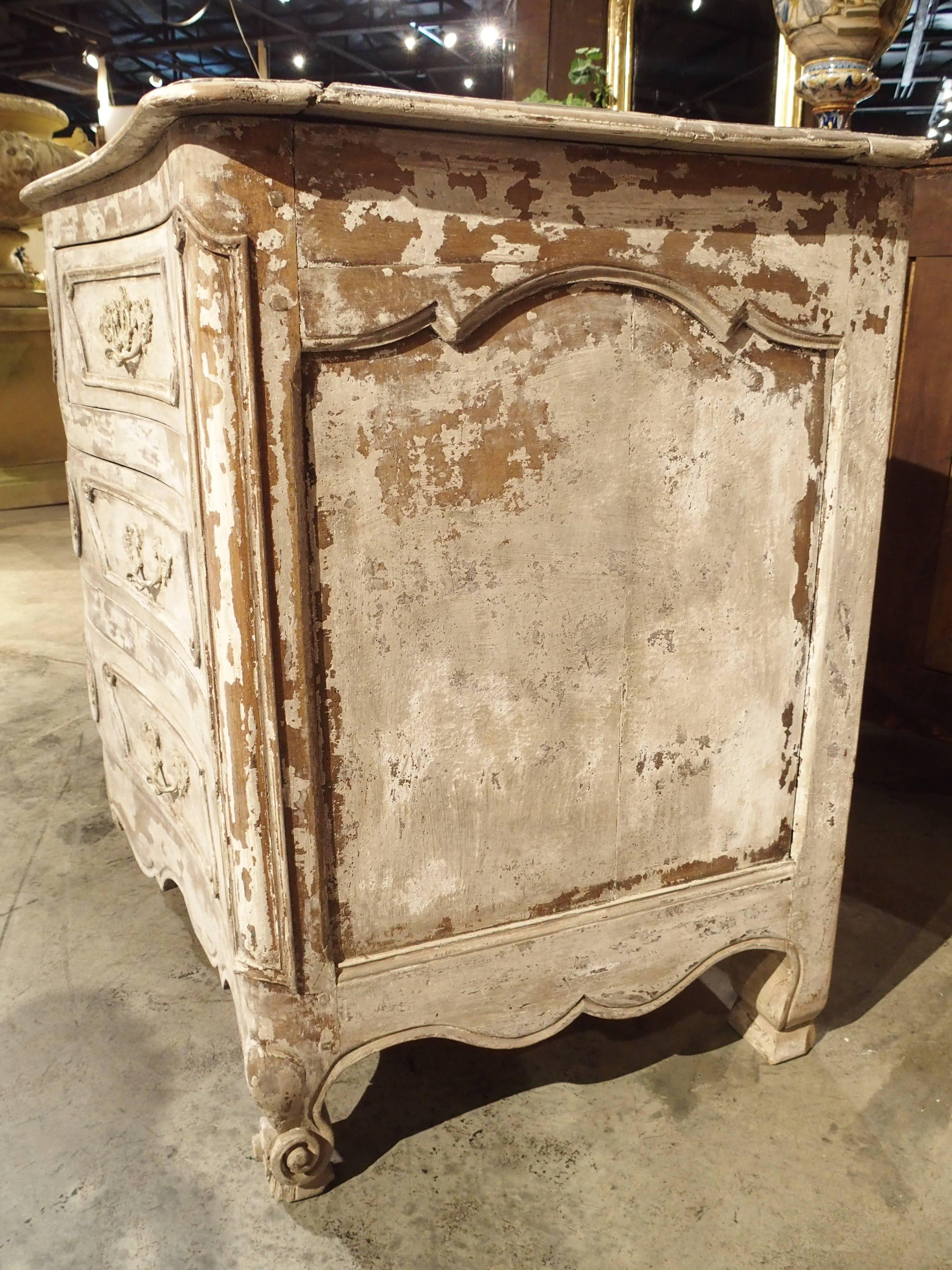 This wonderful Louis XV style painted commode from France dates to the 1700s. Made from walnut wood, it was re-finished/painted sometime in the 1900s. 

It has a rectangular conforming wooden top and a restrained shaped front over a recessed,