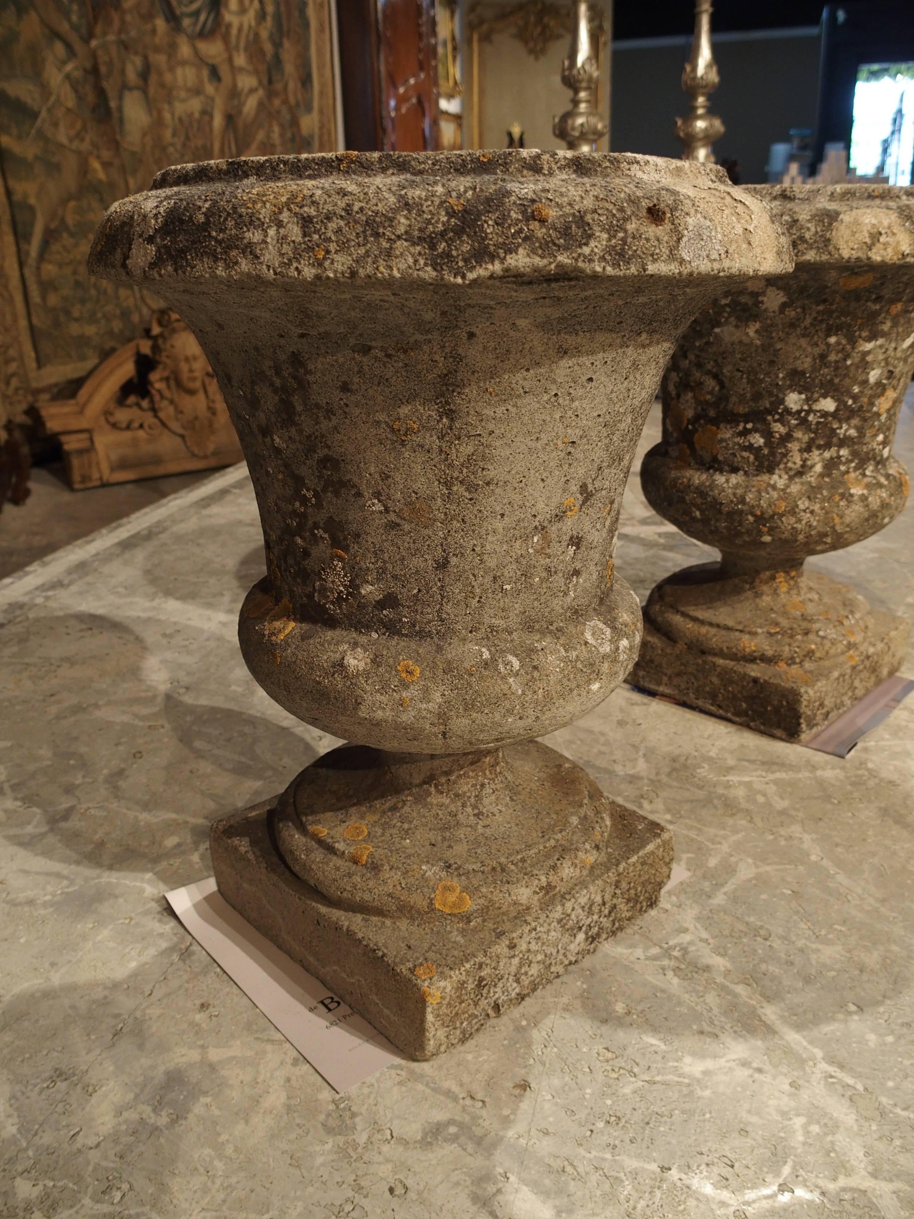 This pair of small Campana stone urns rest upon a square plinth. Versatile in their uses, these urns can be used indoors or outside. There is a small round hole in the bottom of each for allowing the water to drain.

Measures: H 14 1/16, max width