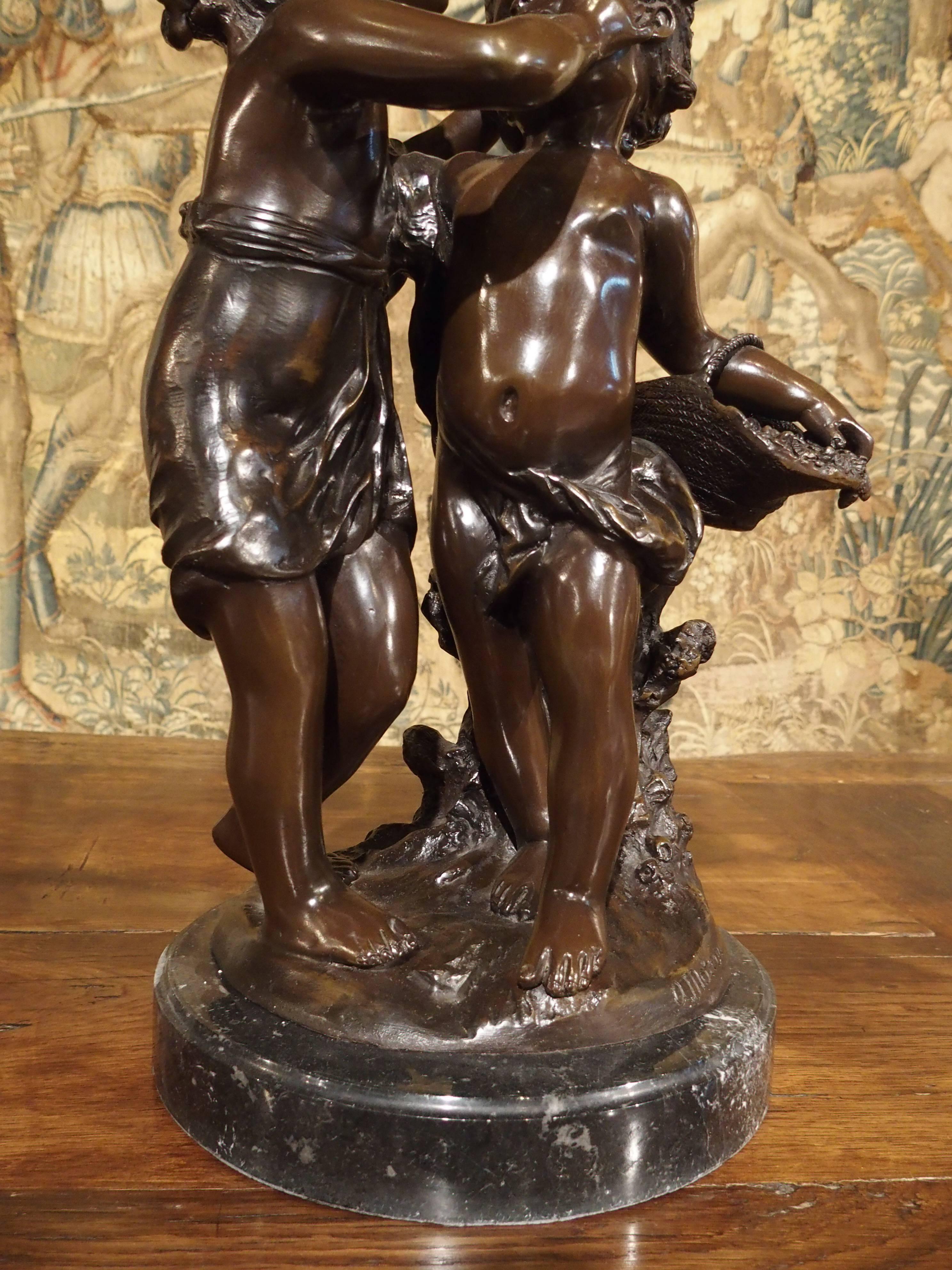 This French bronze features a little girl graciously kissing a younger boy’s forehead. He is leaning against a tree trunk holding a basket of flowers for her. The original was executed by Auguste Moreau in France, in the late 1800s or early 1900s.