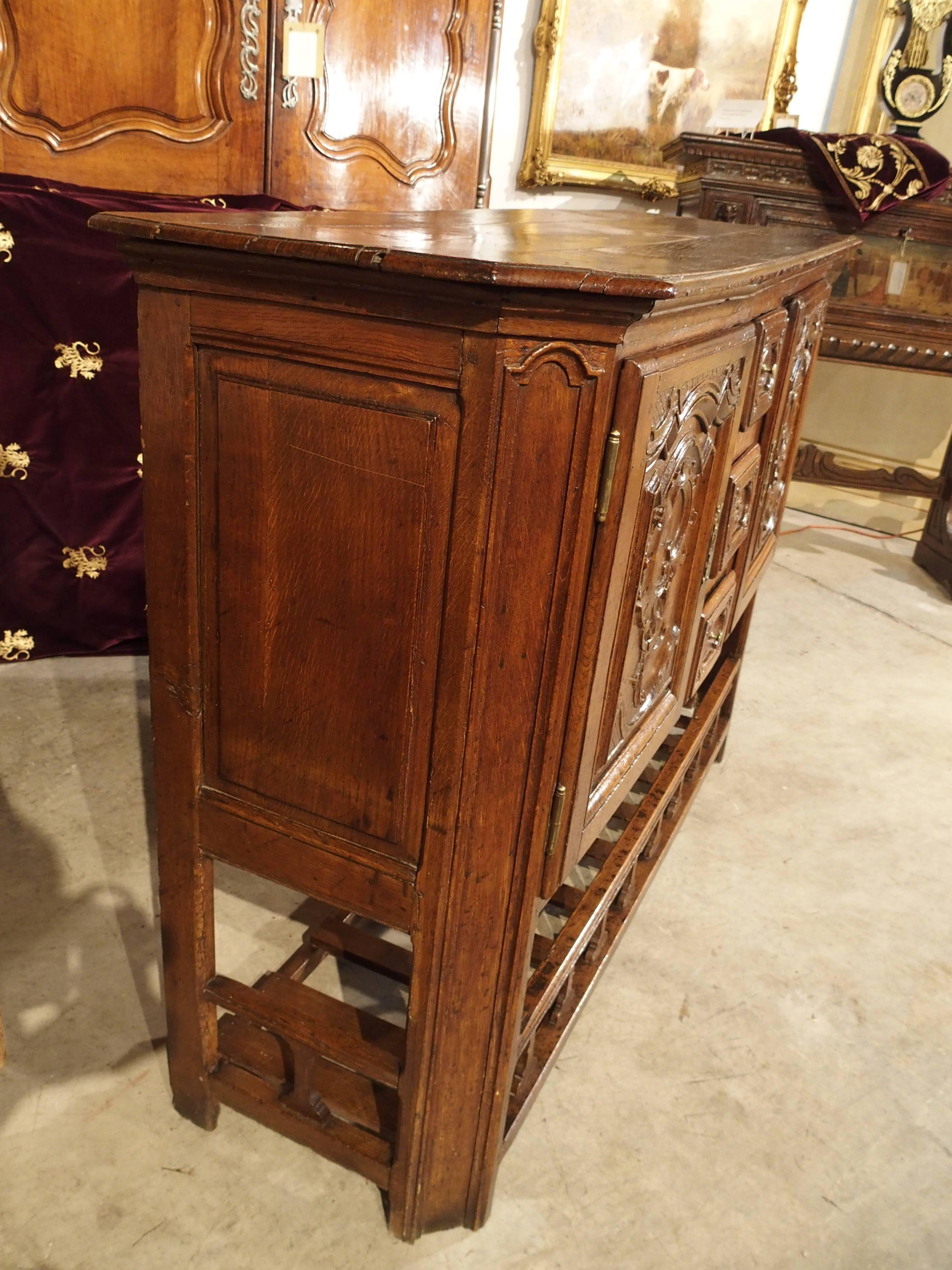 This Louis XV Style buffet was built in the early 19th century. We are considering it Louis XV style because of the beautiful scrolling rocaille motifs on the two front cabinet doors. However, it also has straight lined sides and a useful lower rack