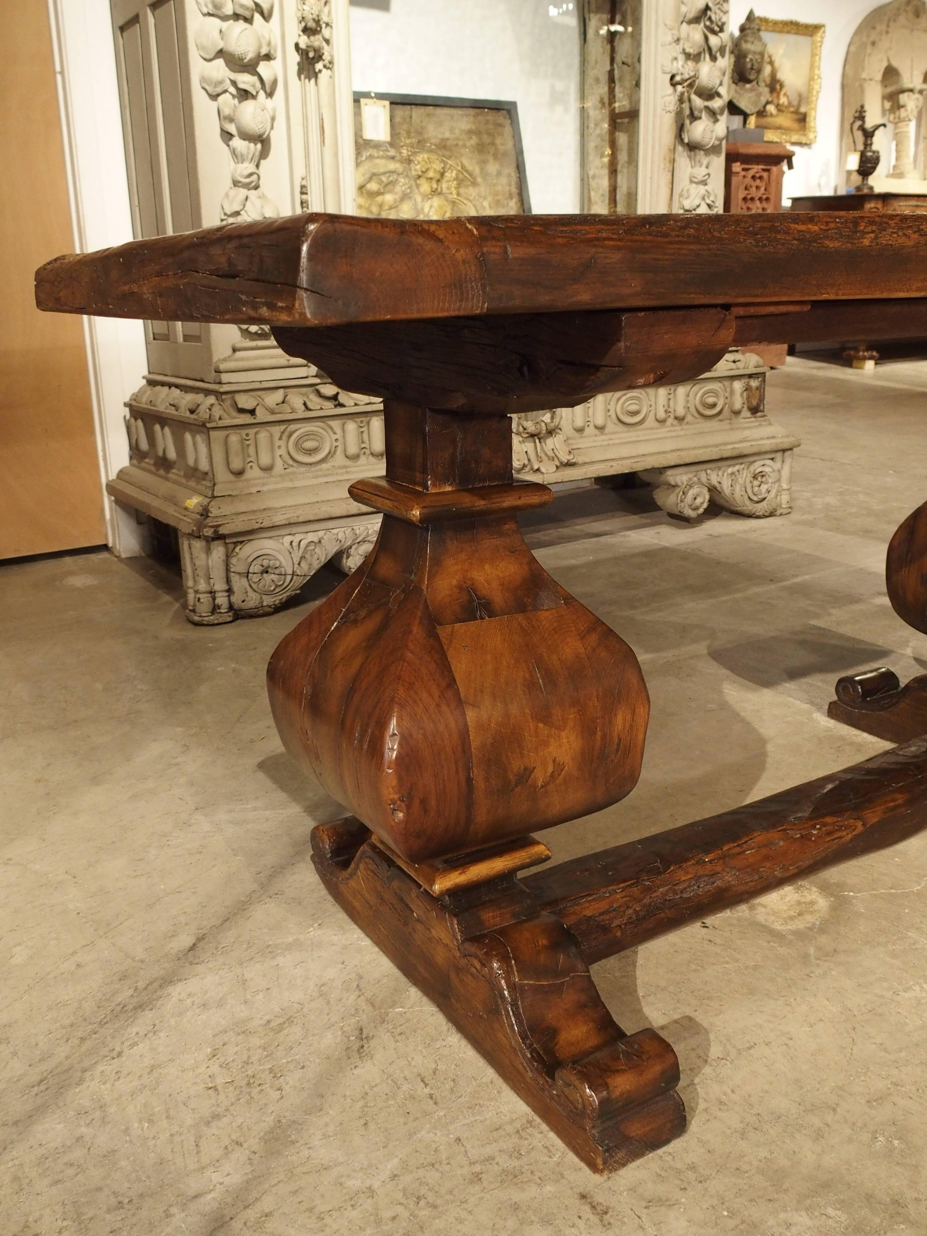 This magnificent French oak sofa table was made with a thick slab of uneven parquet flooring and beam for the stretcher. The baluster shaped legs were more recently carved, and the volute feet are in the French Renaissance style. When a quality
