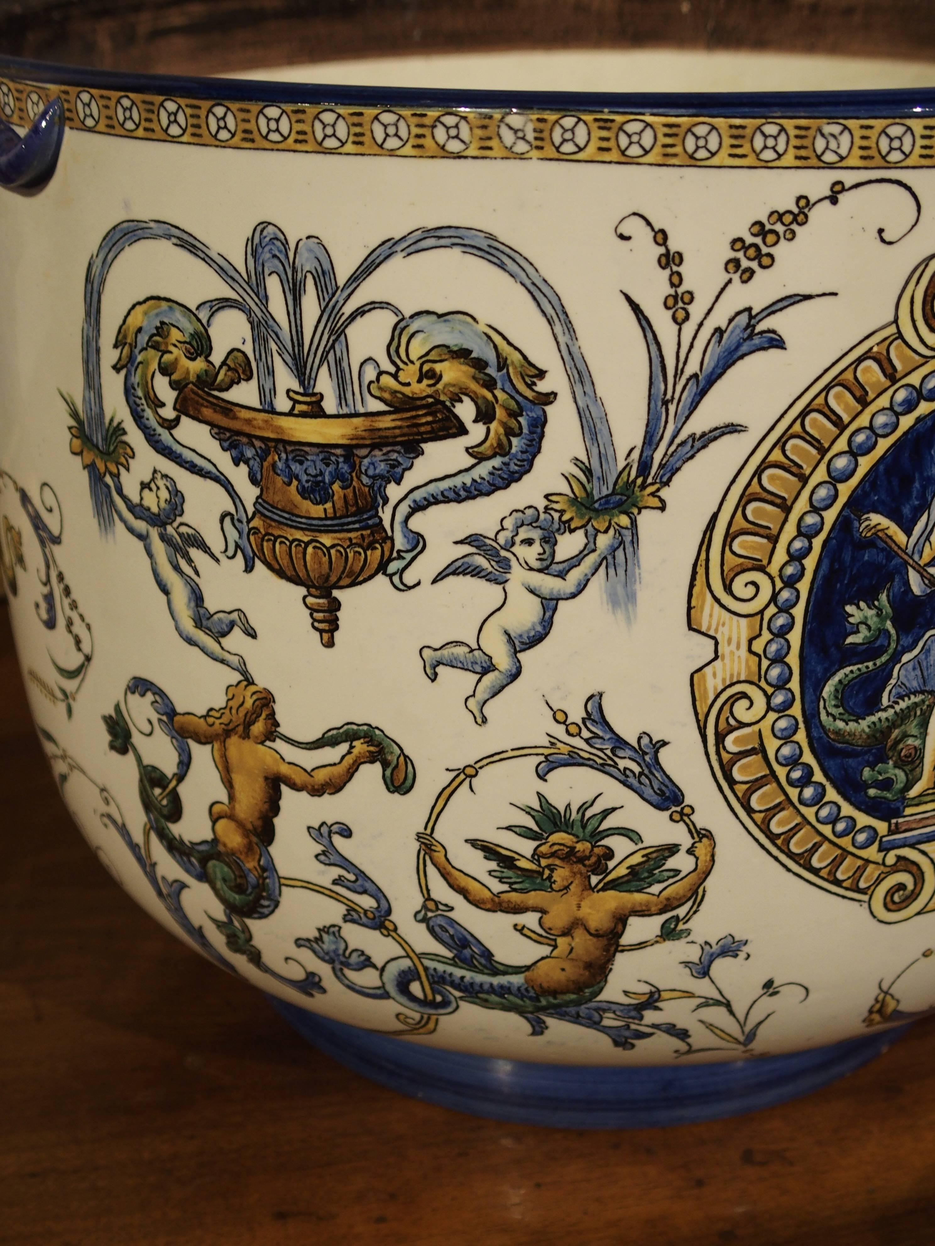 Triton.

This antique French faience jardiniere by Gien has the white ground color of a pattern called Renaissance, manufactured during the time period of 1860-1871. Faience is tin glazed earthenware that allows pigments to be applied in numerous