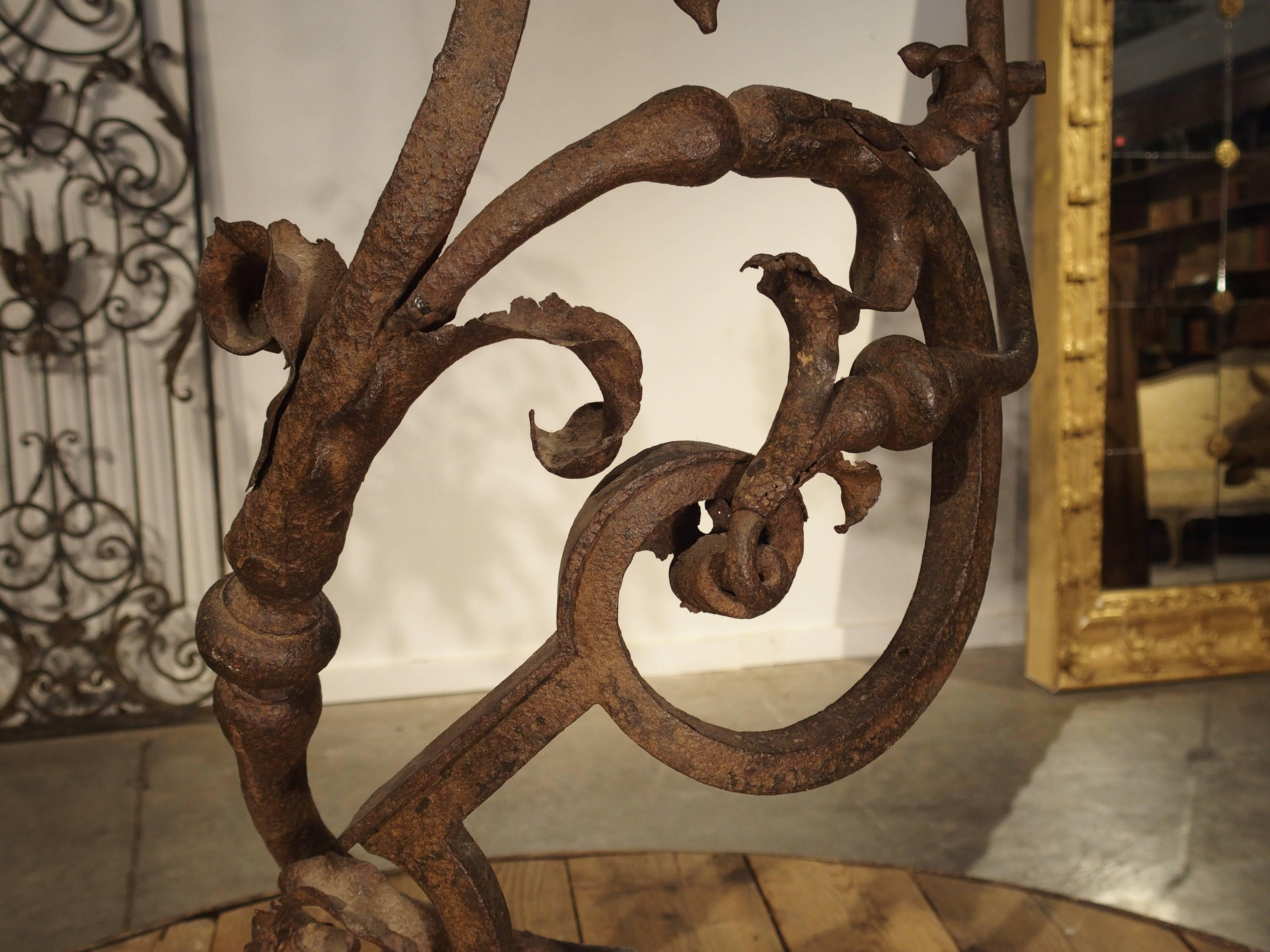 This graceful hand-forged iron stair railing fragment dates to the 1600s. It is high quality ironwork and stands on its original stone housing. There are some complete acanthus leaves in areas with fragments elsewhere, all very delicately made by