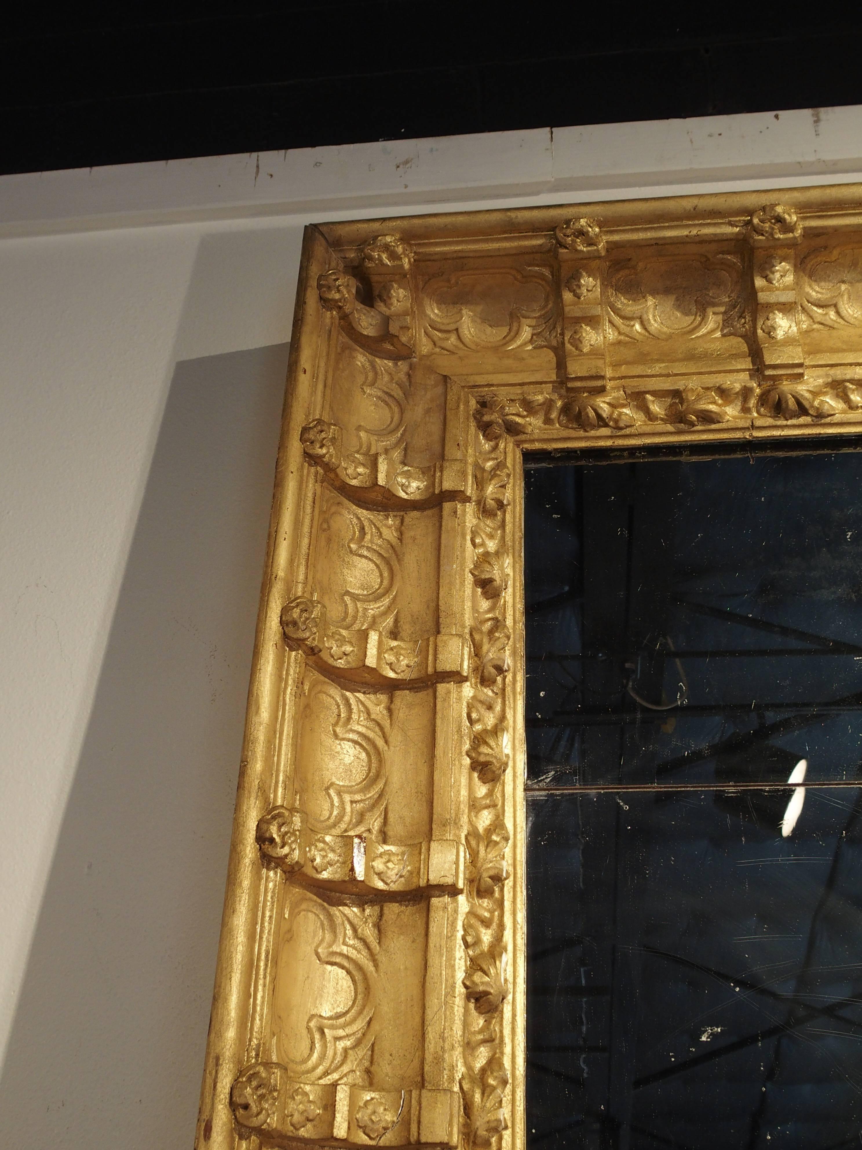 This very large and dramatic mirror is constructed from 19th century glass mirrors and crown moldings from a room in a petite chateau in Provence. The elements are period Napoleon III and the gilding was done more recently. The individual mirrored