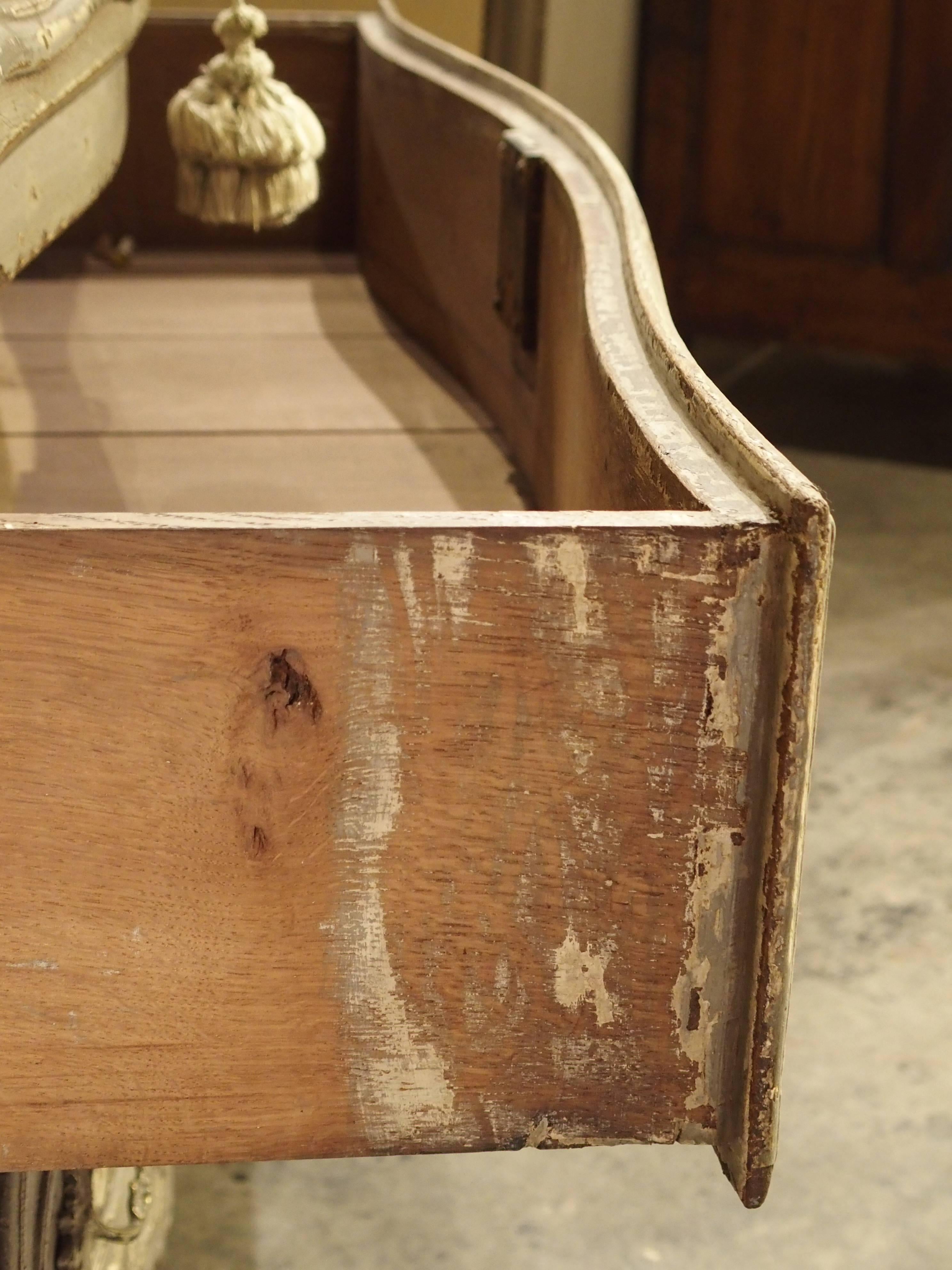 This is a wonderful antique French commode with a parcel paint finish from Provence, dating to the end of the 1800s. It has a rectangular conforming marble top and a restrained shaped front over a recessed, conforming frieze. There are three drawers