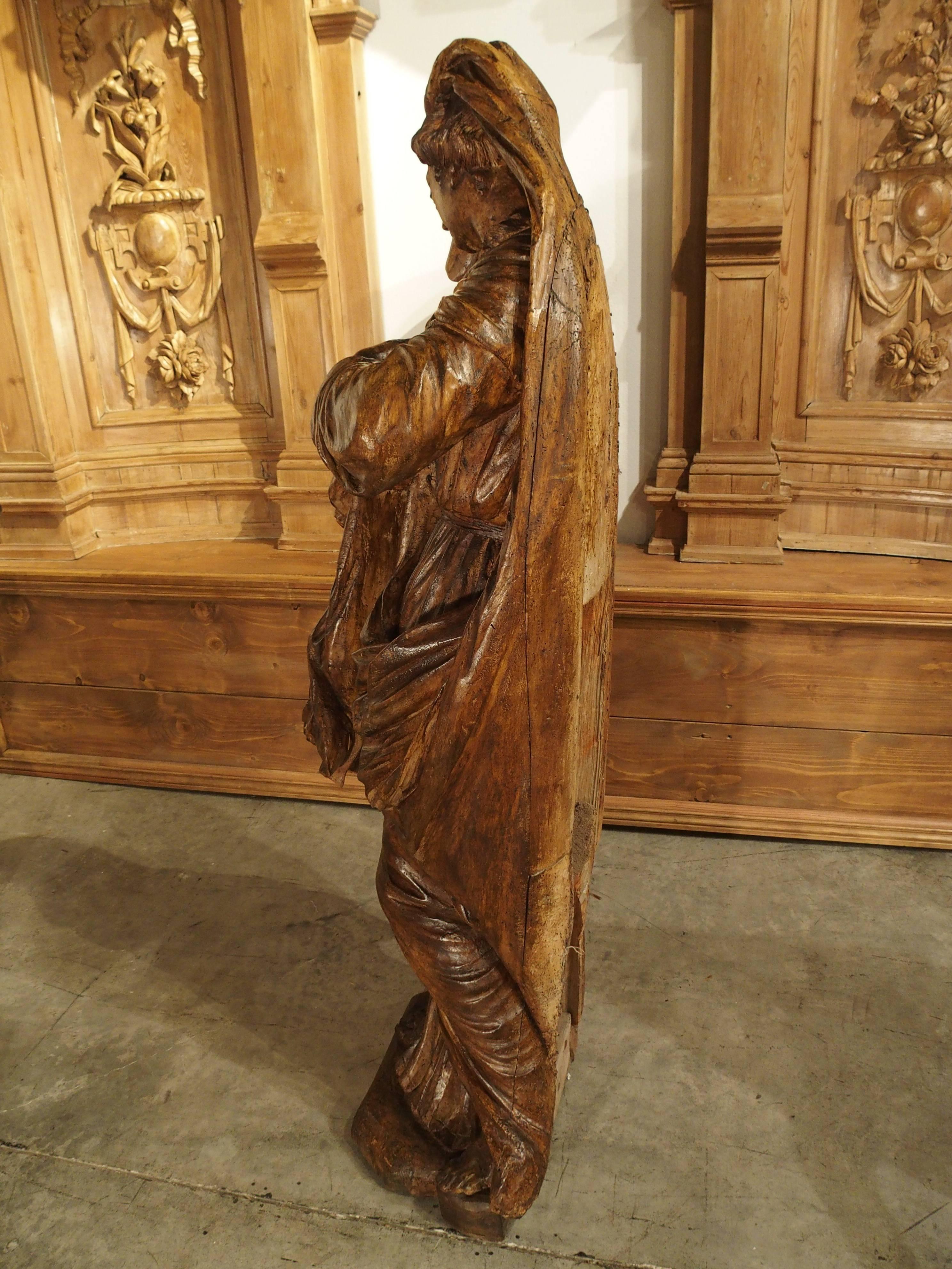 This magnificent antique French carved statue is of a grieving Virgin Mary and dates to, circa 1660. The carving is very meticulous and to scale, as shown by the placement of the multiple folds in her robe. The carver knew where to create the