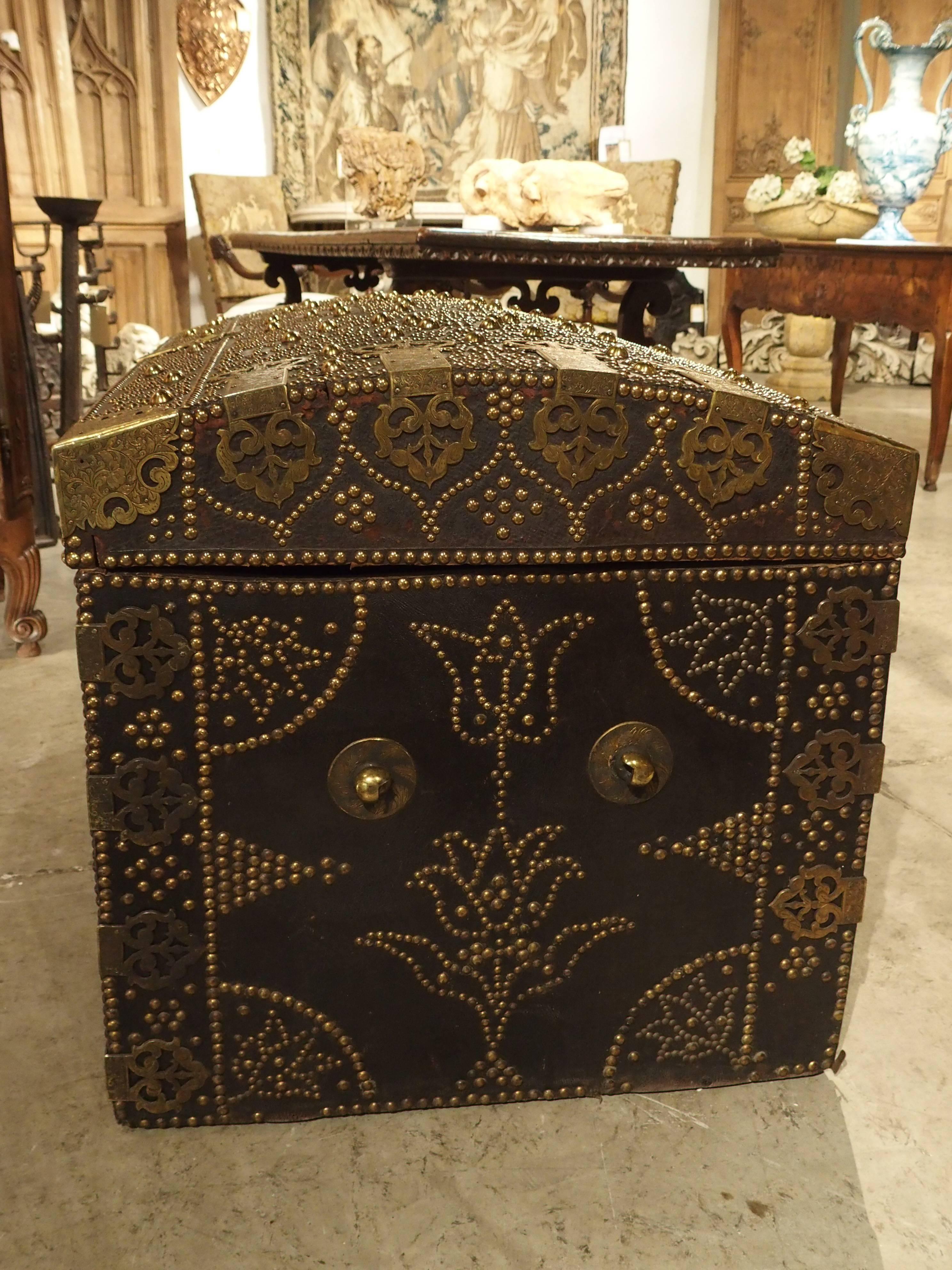 Richly and abundantly decorated leather trunk with finely chased Royal crown fittings and studs. This is a rare piece and strikingly similar to the leather chest residing in the Victoria and Albert Museum: 

The leather has been affixed to its