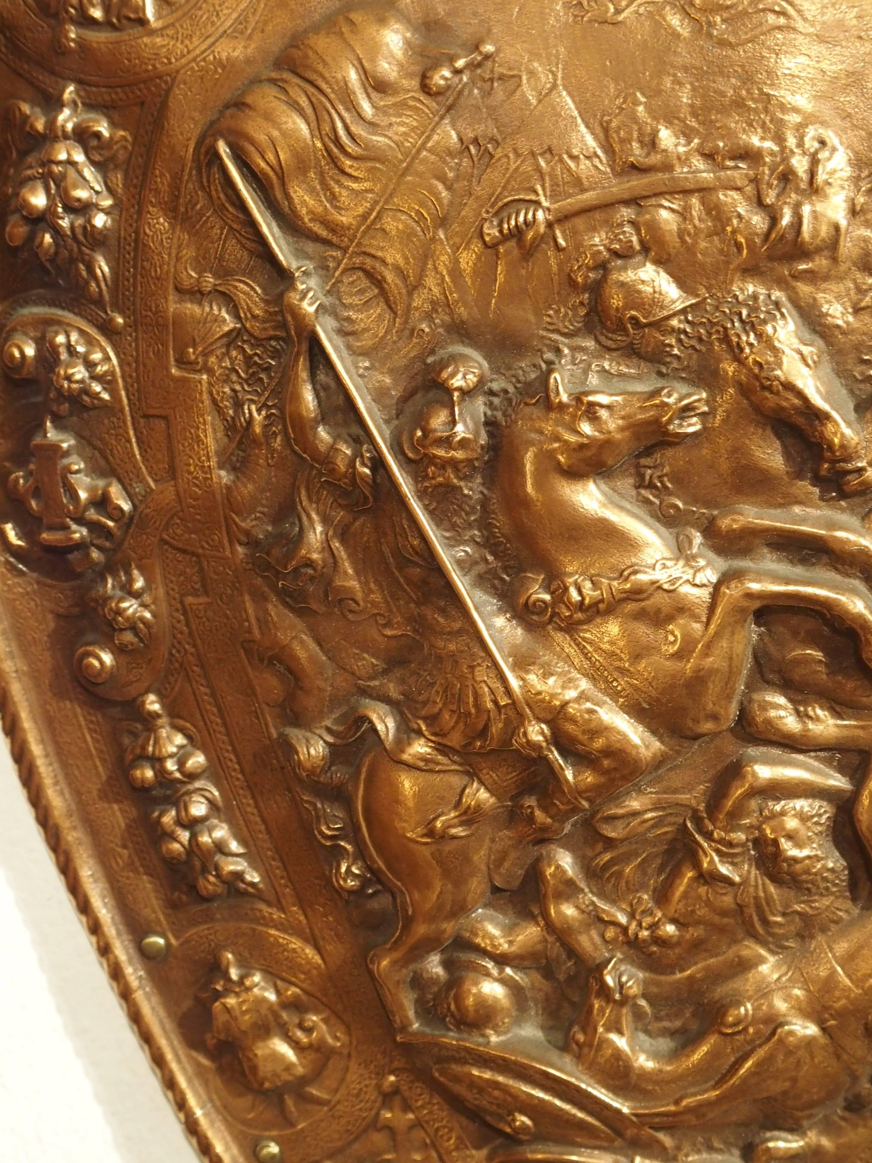 This stunning French copper parade shield is from the 1900s. The minute details in some areas are absolutely wonderful. The more you look at this shield, the more you begin to see other details. The scene depicts a Roman or Grecian battle scene at