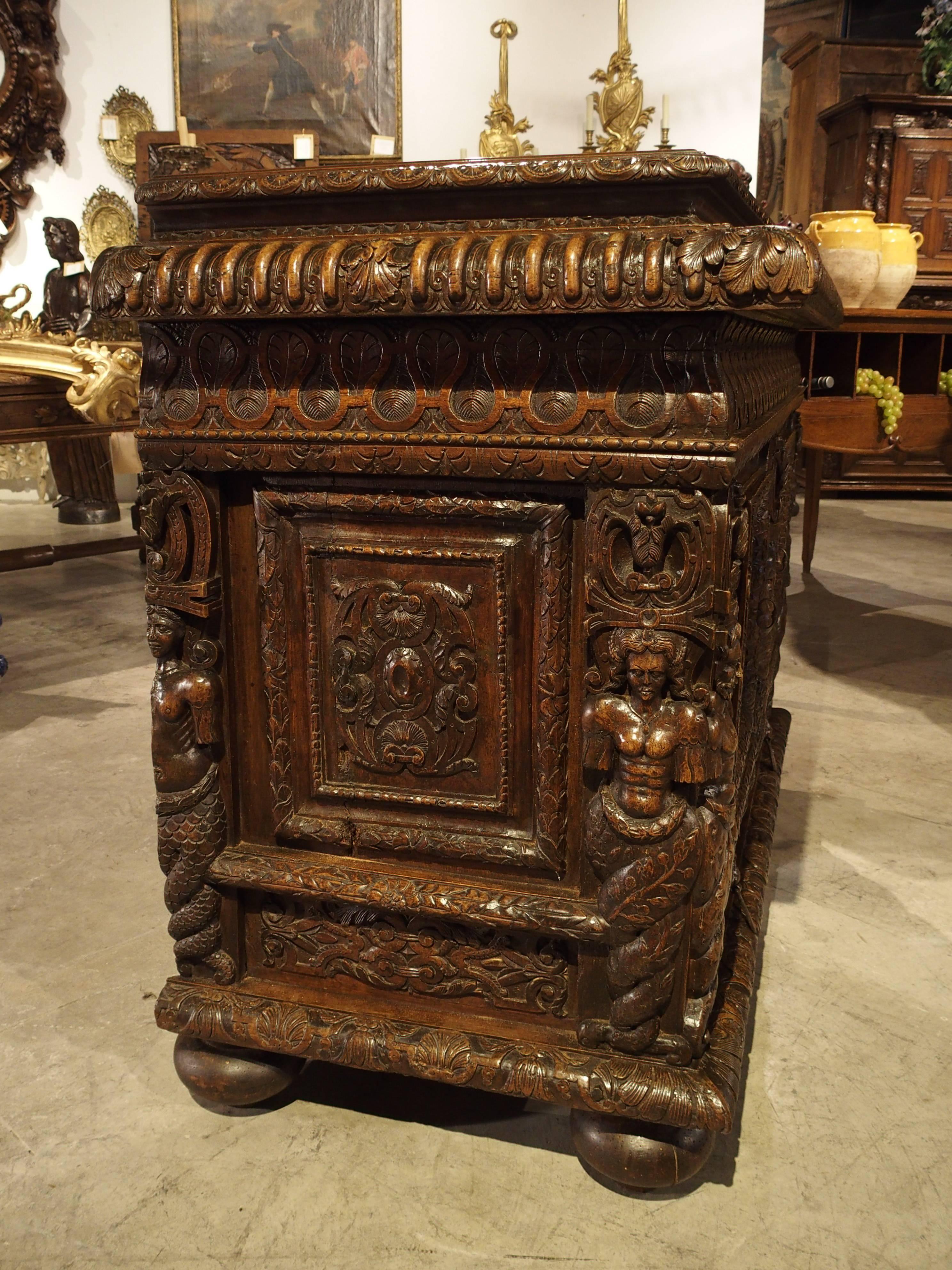 This richly decorated antique French walnut wood buffet has some of the most intricate and tiny carvings that are still visible after several hundred years. It is composed of period Renaissance elements that were mated with 1800s sections (such as