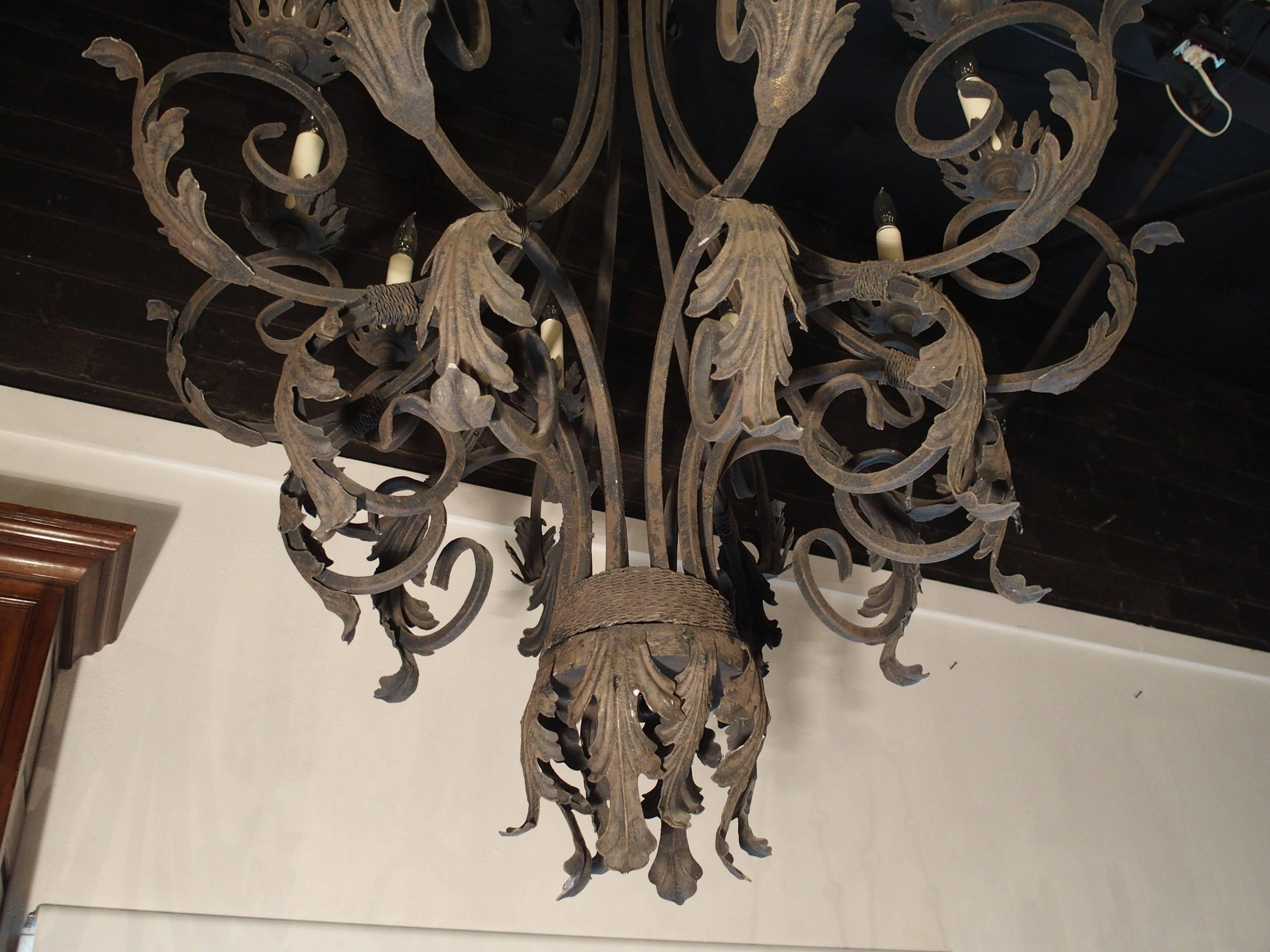 This elegant cast and shaped iron chandelier from France is perfect for an area requiring a tall chandelier. It has a height of 52-1/2
