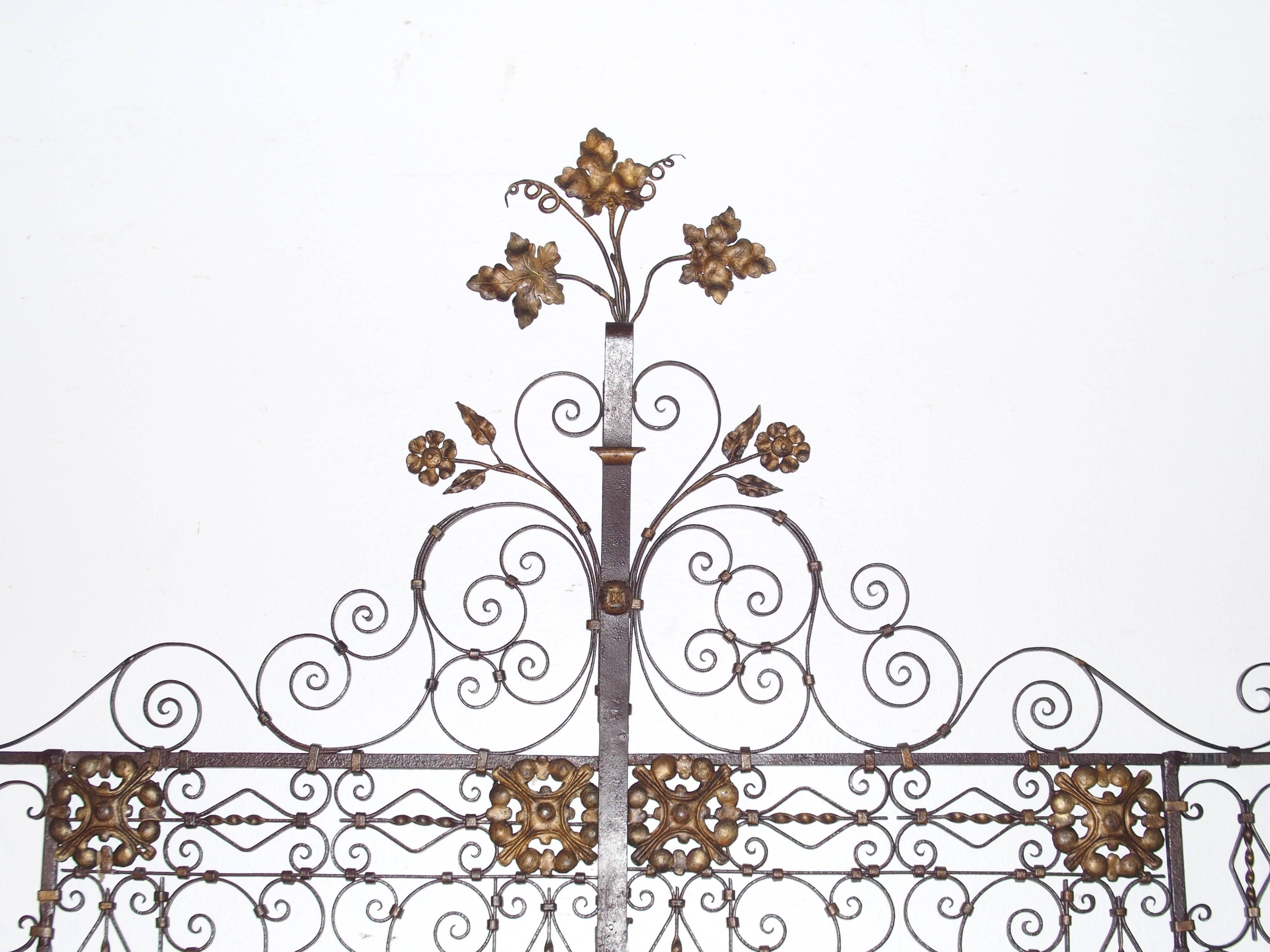 These stunning forged iron antique gates have similarities to Viollet-le-Duc’s Notre Dame gates. More specifically, we see it in the banding together of the stems of the flowers and the tall central ornaments above the gates. Therefore, we can say