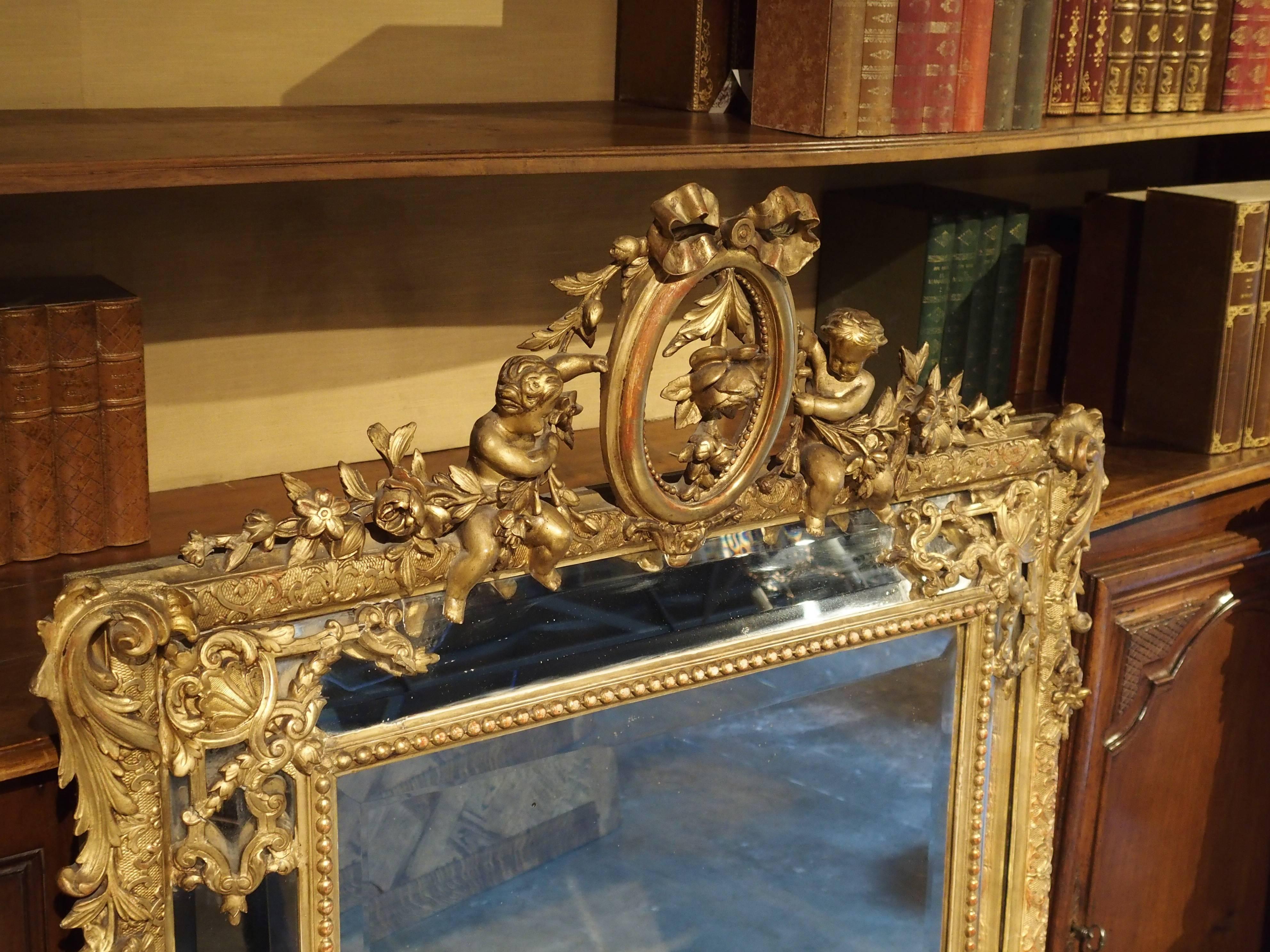 This elegant, antique French, giltwood, Louis XVI style mirror is called a Miroir a “Parcloses”. It has four canted side mirrored panels separated and held in place from the main center mirror by giltwood ornamentation. The unusual arrangement of