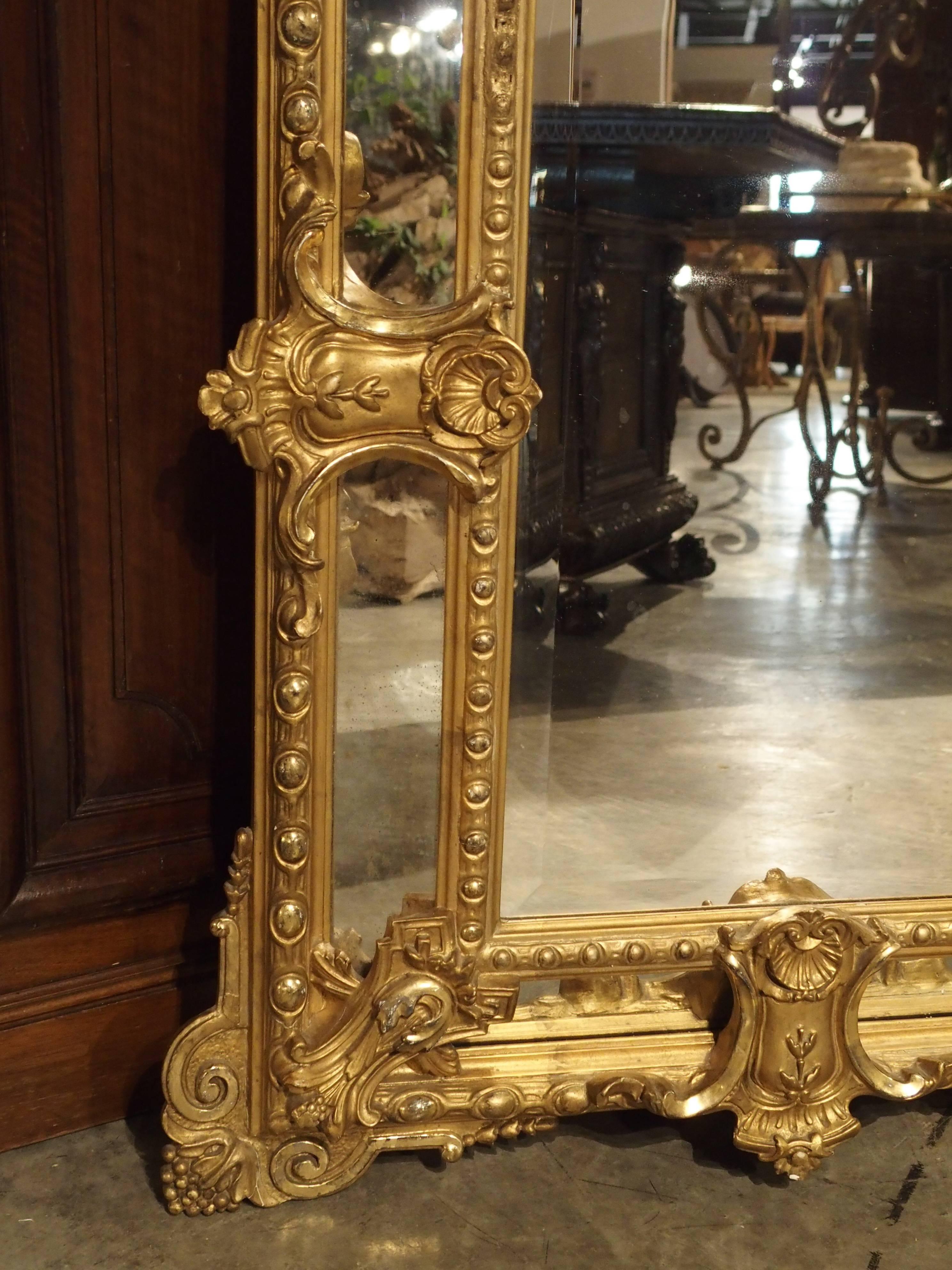 This elegant, antique French, gilded, Louis XV style mirror is called a Mirror a “Parcloses” in France. It has four canted side mirrored panels separated and held in place from the main center mirror by giltwood ornamentation. The unusual