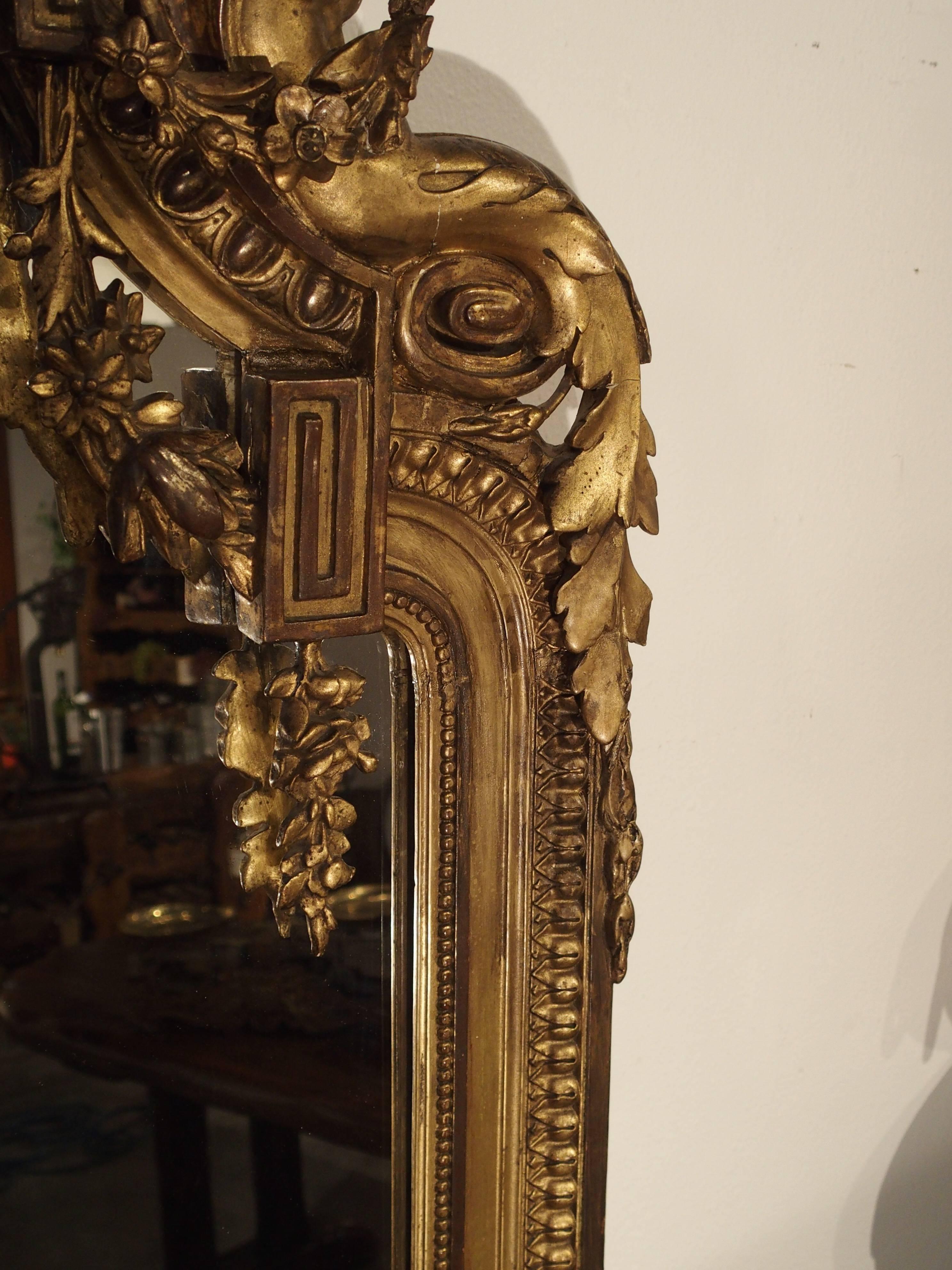 This magnificent giltwood, Louis XVI style mirror exemplifies what Louis XVI embraced in ornamentation---neoclassical simplicity. Straight lines were interrupted by ornament , mediating severity. There was always a central axis around which motifs