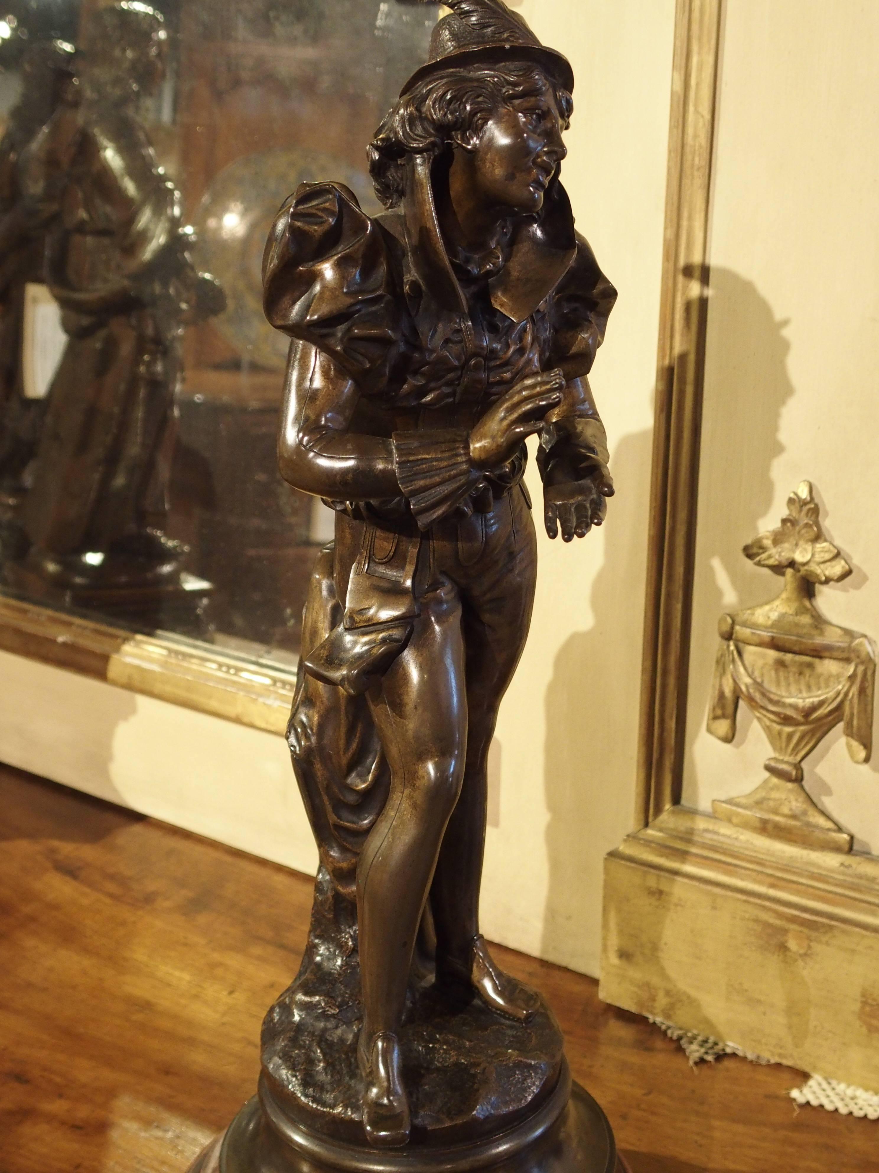 This nearly 22 inch tall charming antique patinated bronze statue depicts a gentleman in period dress, smiling and clapping his hands. He is on a shaped, round, bronze and marble base. The signature of the artist is on the bronze, but is