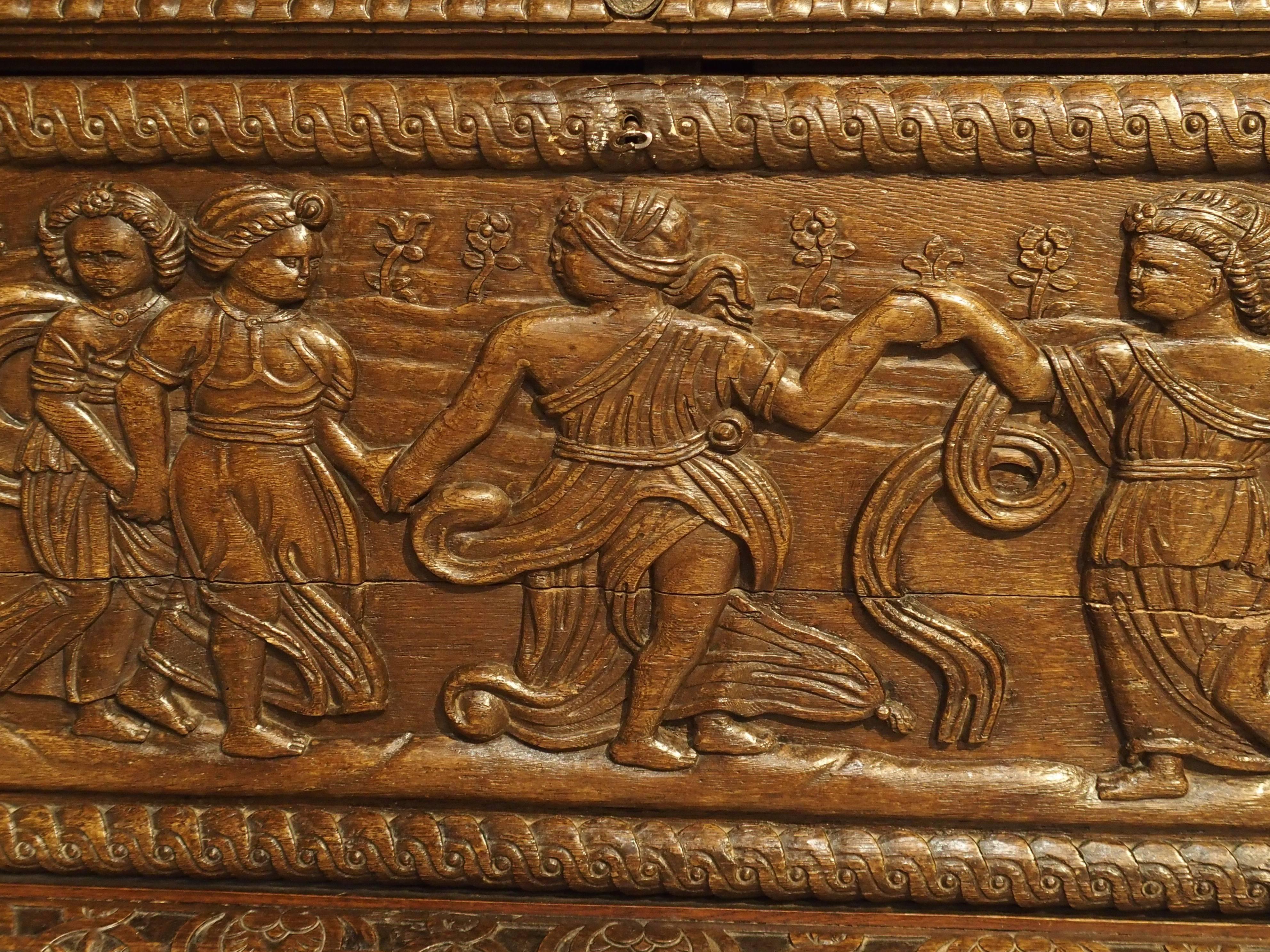 From Normandy, this magnificent French trunk is made largely of period Renaissance elements of the 16th century. The long front panel of maidens dancing in a garden with foliage and flowers, typical of the period.   The entire front panel opens