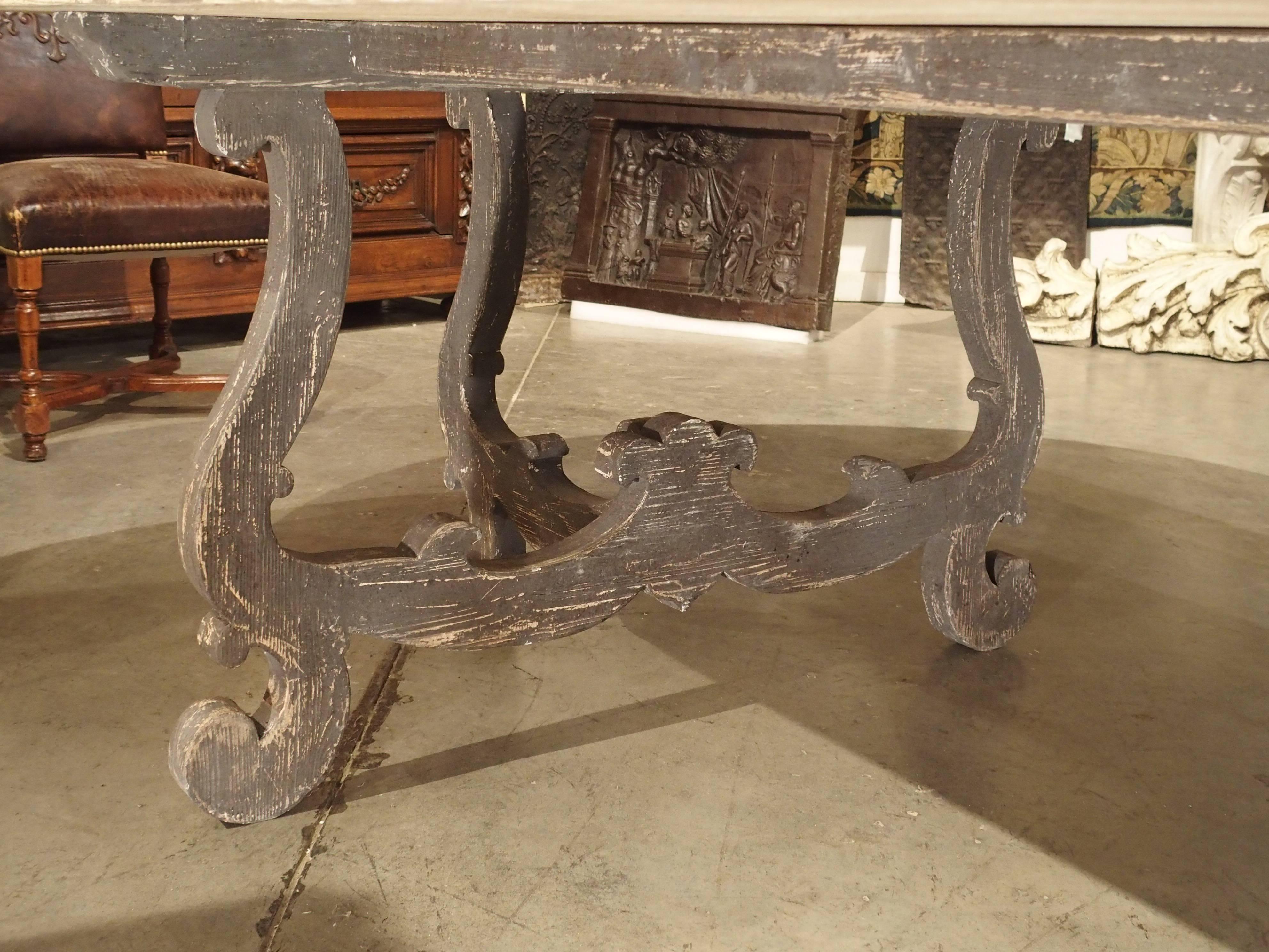 Table comes apart and two ends can be used as console tables.

This parcel paint Italian dining table has a large width of nearly 5 feet. The carved pine legs ends are lyre shaped and parcel painted a nice grey color. One of the most interesting