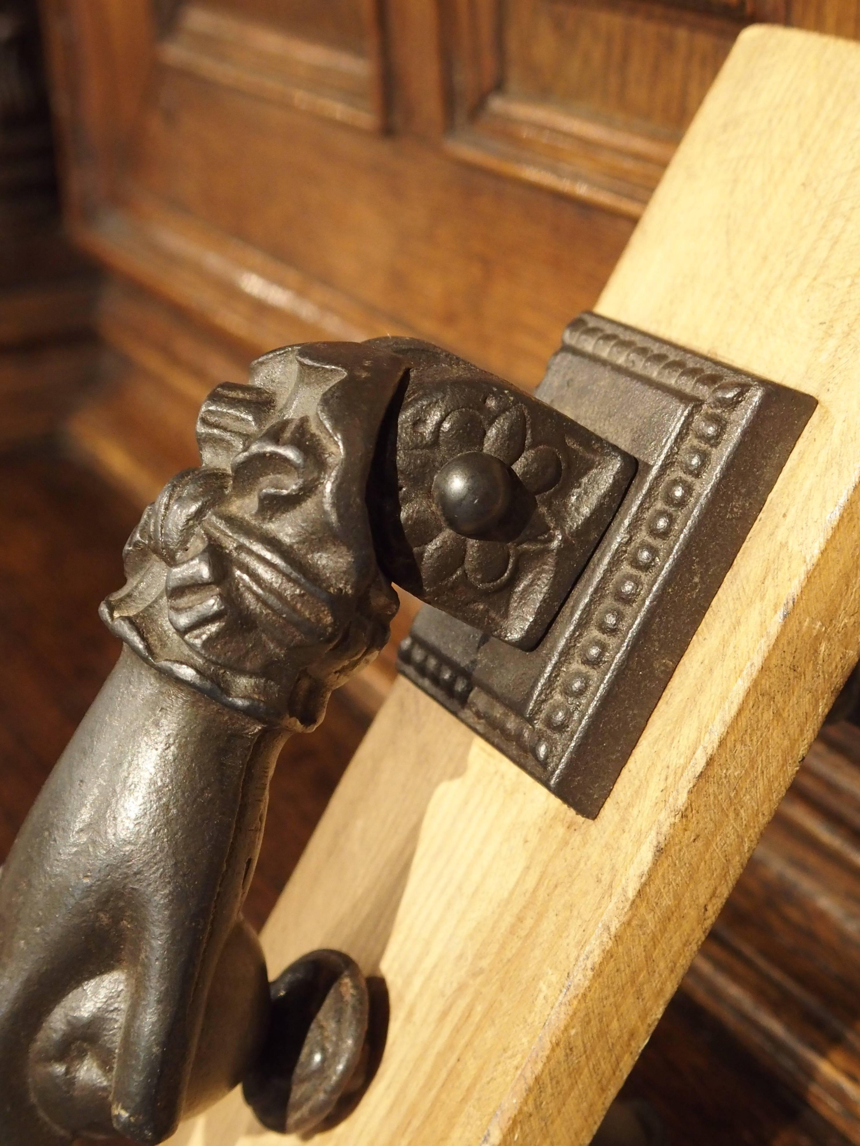 This is a French cast iron door knocker in the shape of a hand clutching a fruit. There is a ring on the middle finger and ribboned cuff on the wrist. This beautifully cast French door knocker will be an attribute to any entrance door.