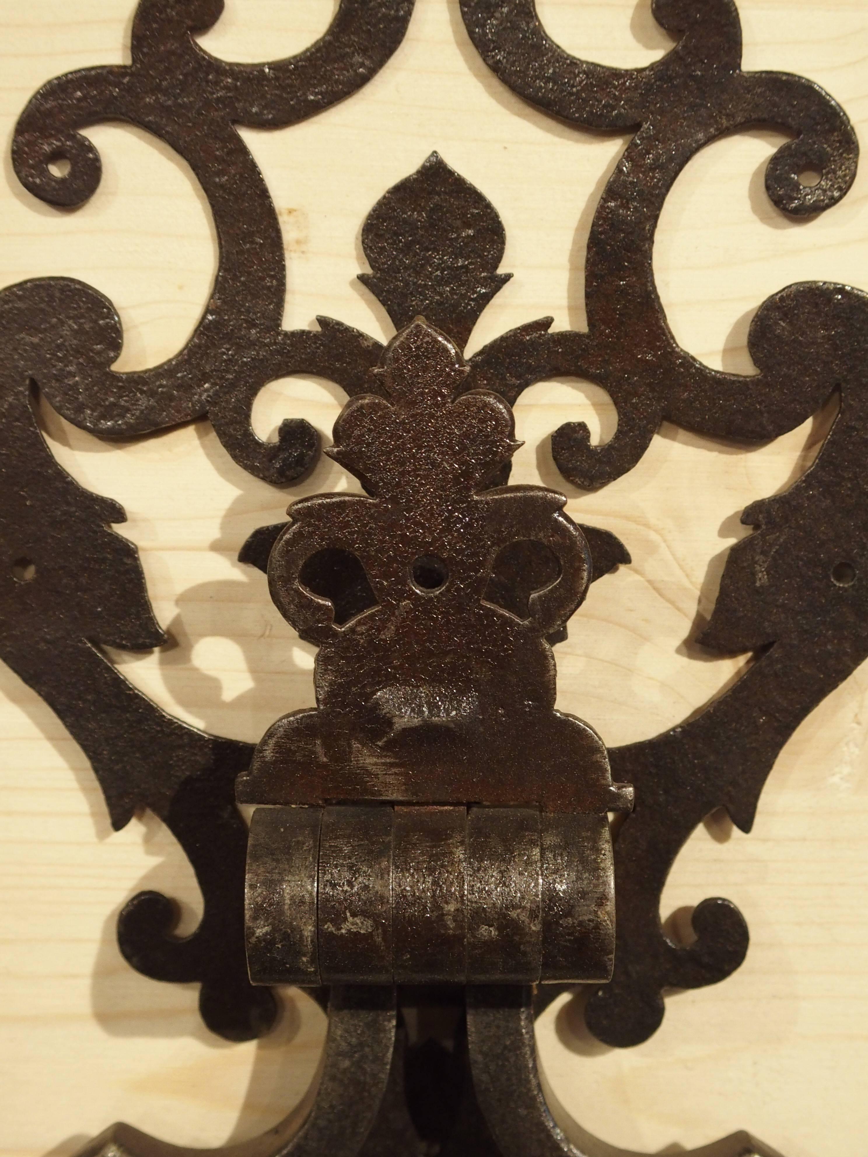 This iron door knocker is modeled from an 18th century door knocker found on a door at a chateau in the Luberon area of Provence France. This knocker is beautifully cut with different stylized versions of the fleur-de-lis on it. The door knocker