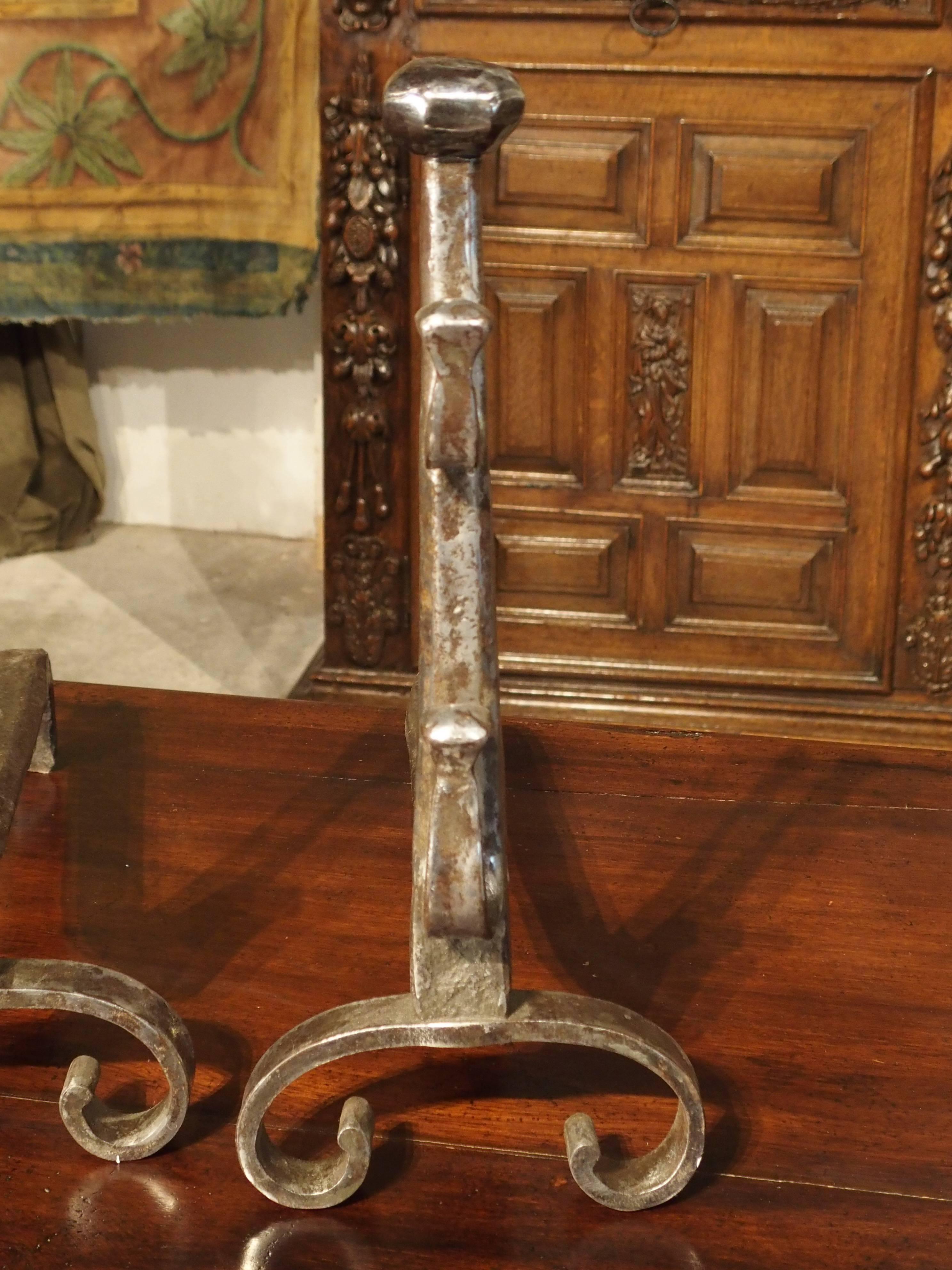 These artistically hand-wrought and hammered, 17th century andirons can be used in any style of design because of their elegantly simplistic design. They have recently been brushed with a wire bristled brush and waxed with a clear paste wax, which